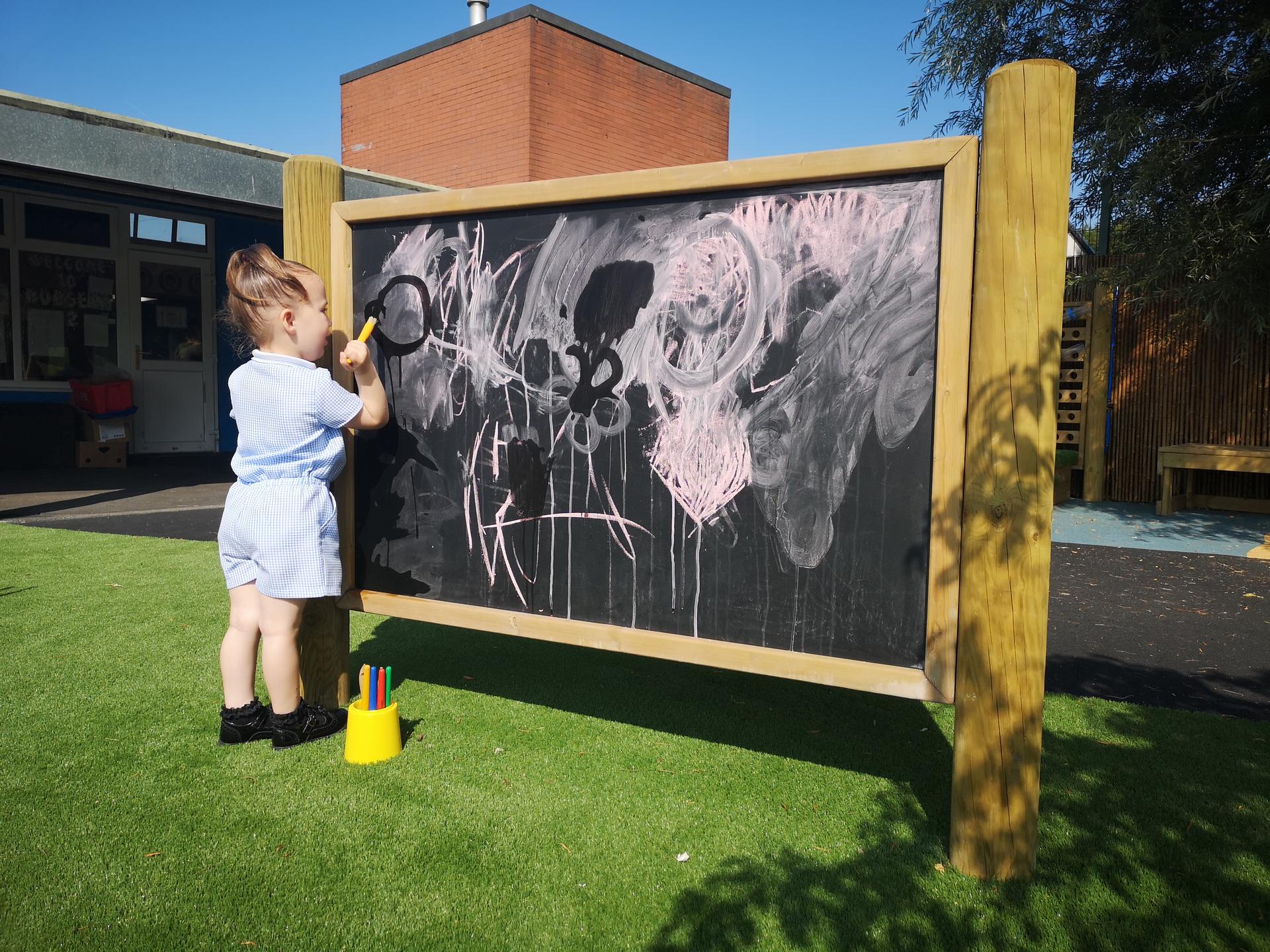 Giant wooden chalkboard on posts from Pentagon Play