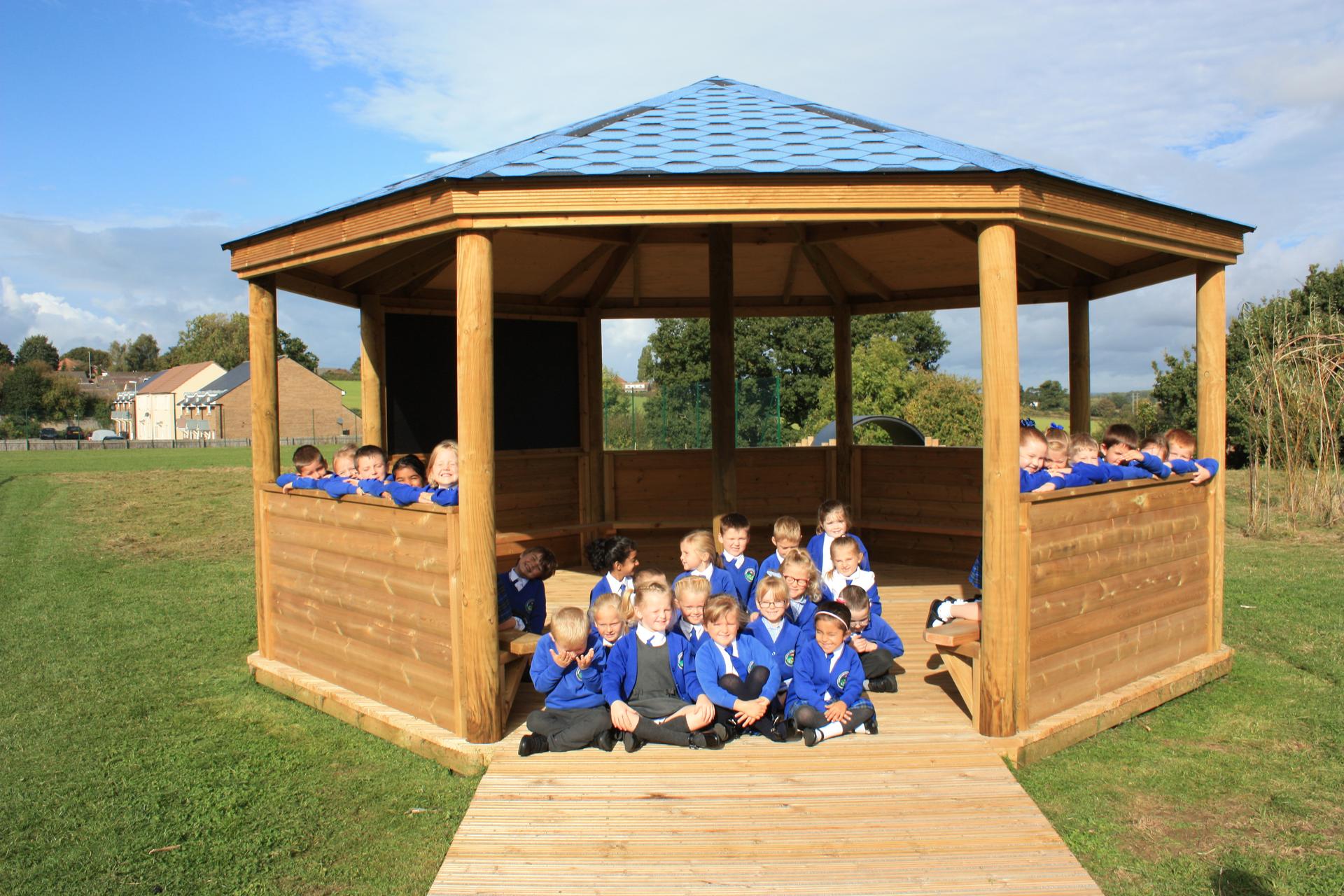 Wooden 6m Octagonal Gazebo with decked base in a school playground.
