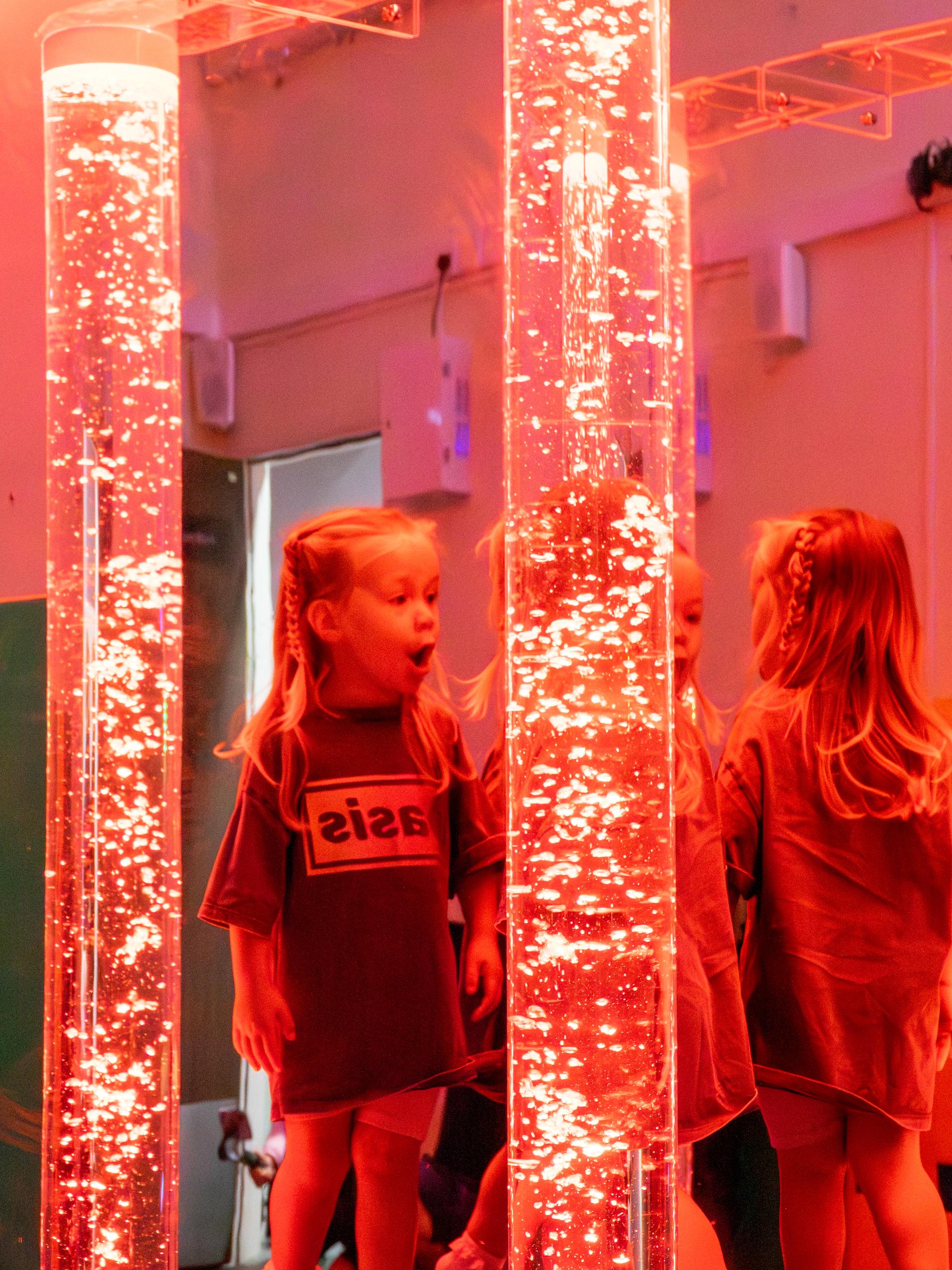Two young girls playing with a large sensory bubble tube