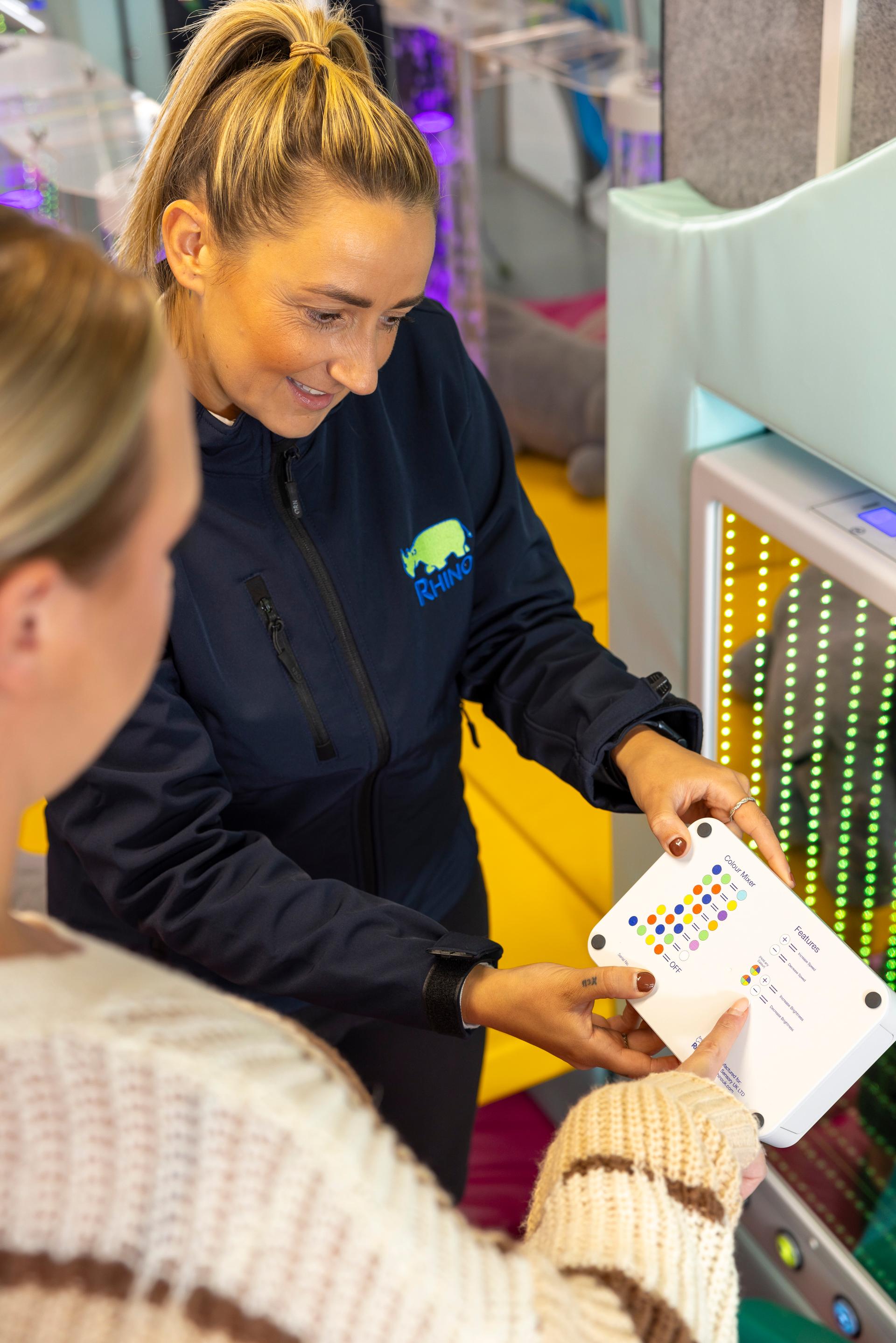A woman holding a colour mode chart for the colour control buttons.