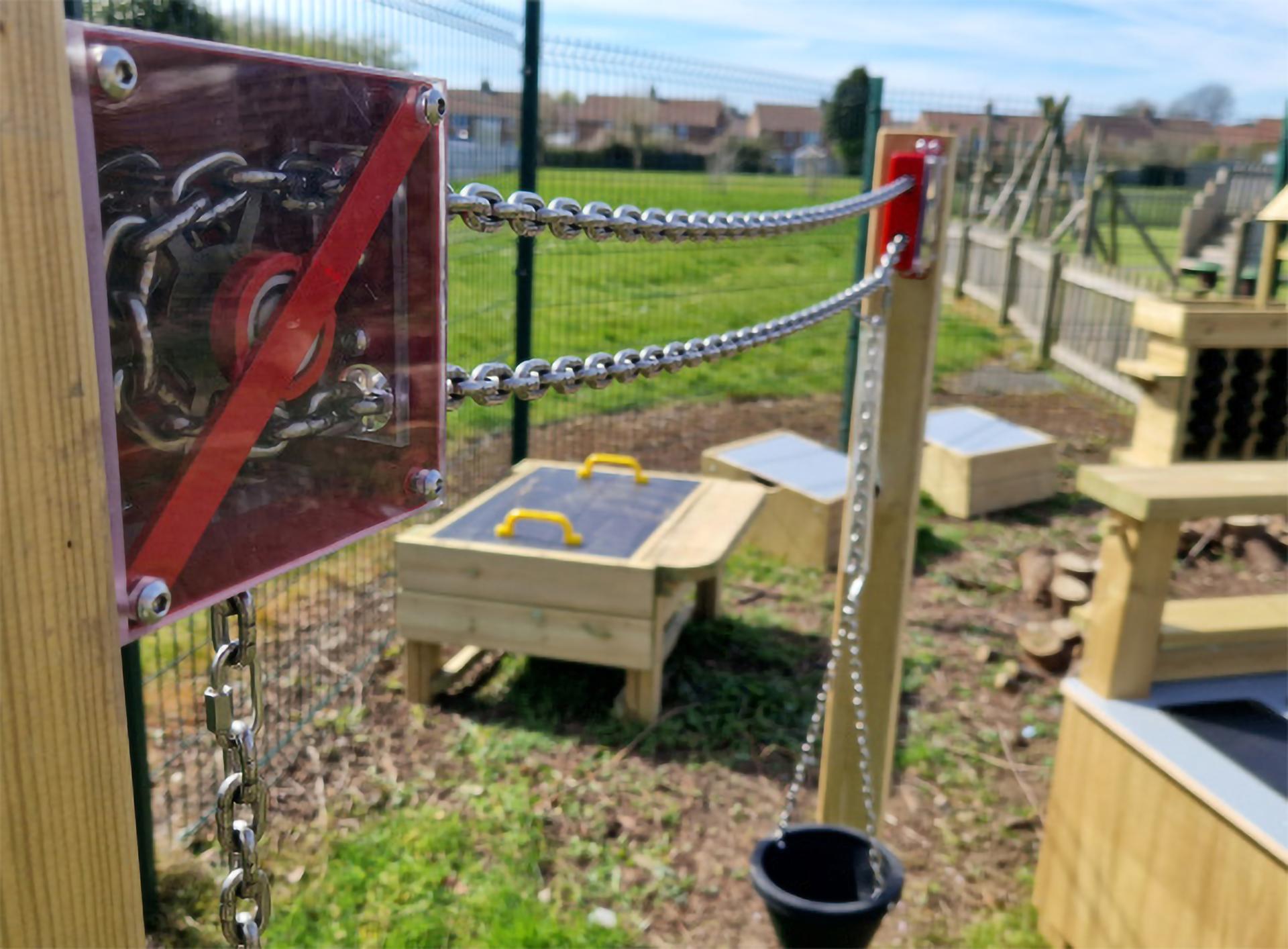 A Chain and Pulley Materials Mover placed on a playground, with a focus on the chain.