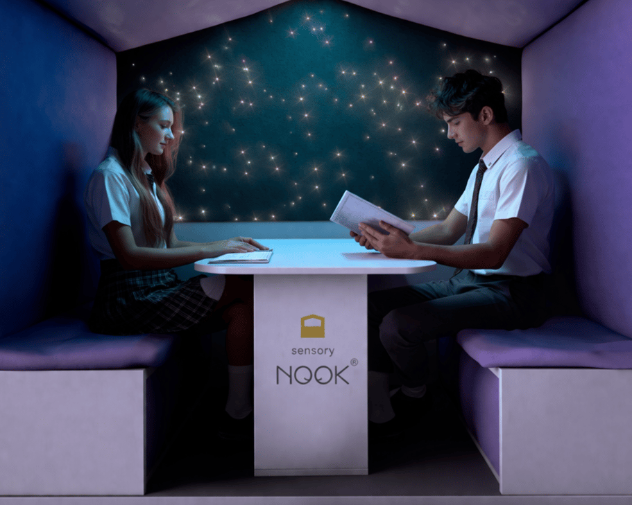 Two high school children are sat within the Sensory Nook, reading books.