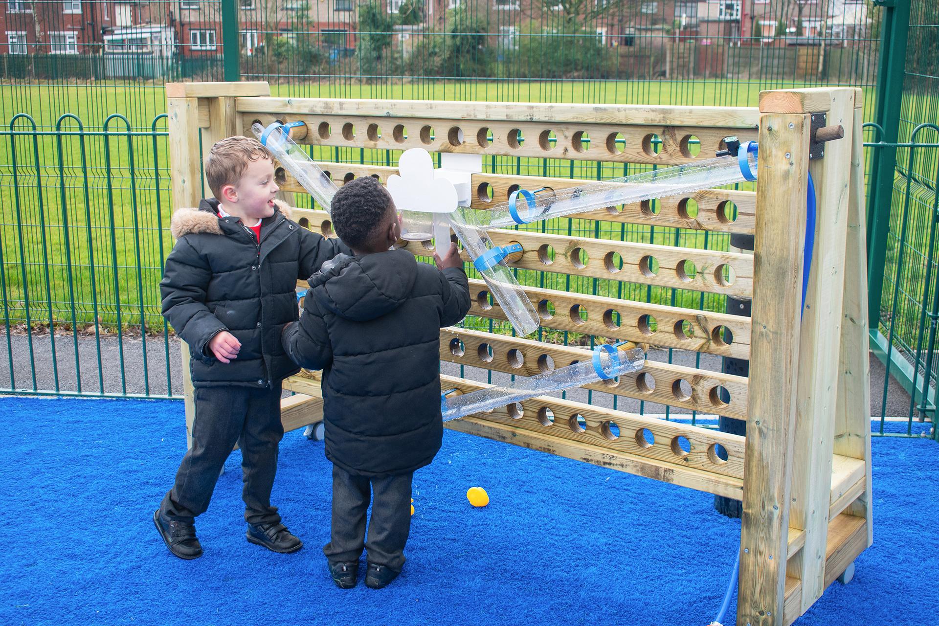 Two boys setting up the movable water wall, happy with excitement