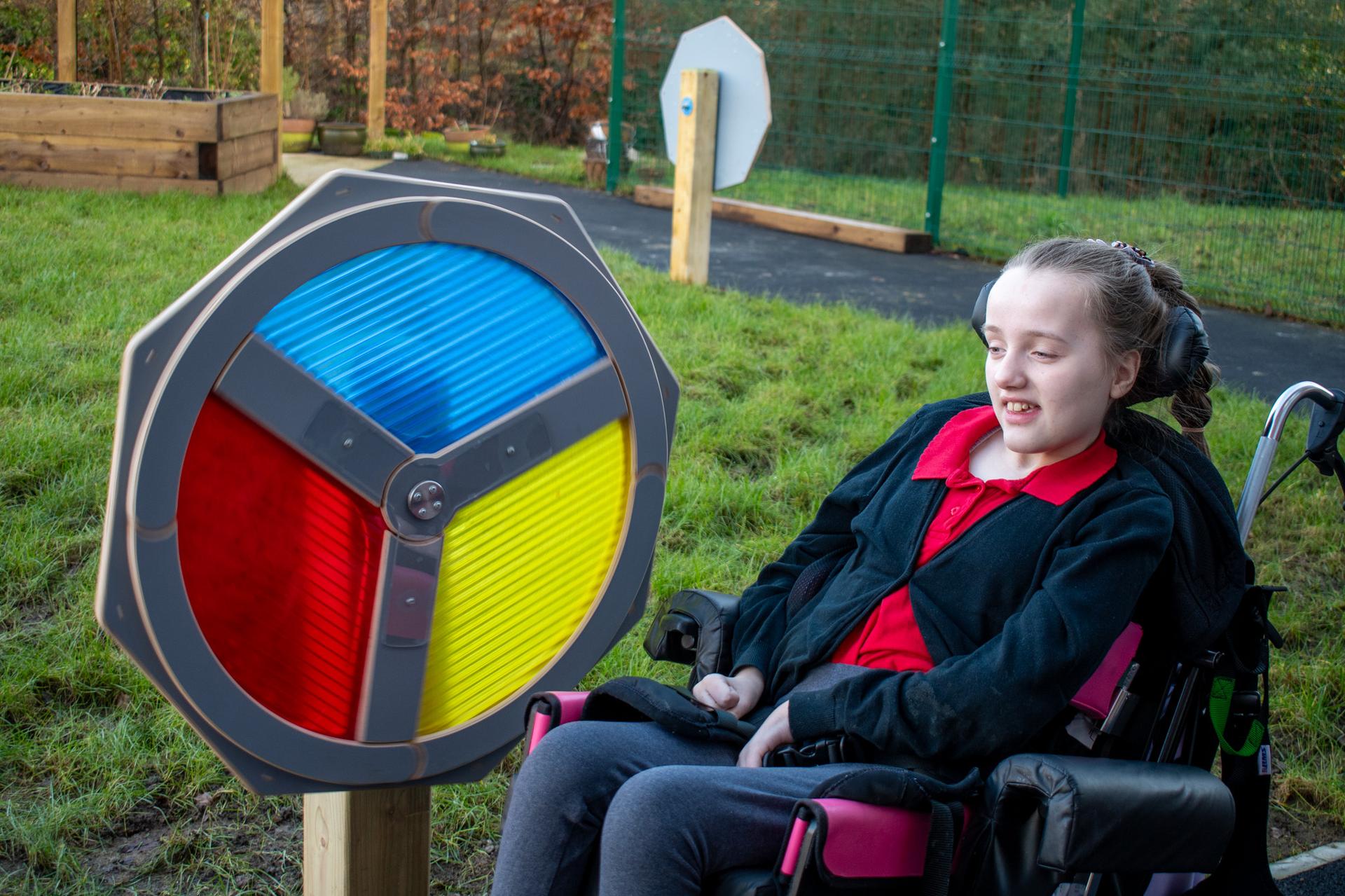 A disabled girl playing with the Light Sensory Spinner.