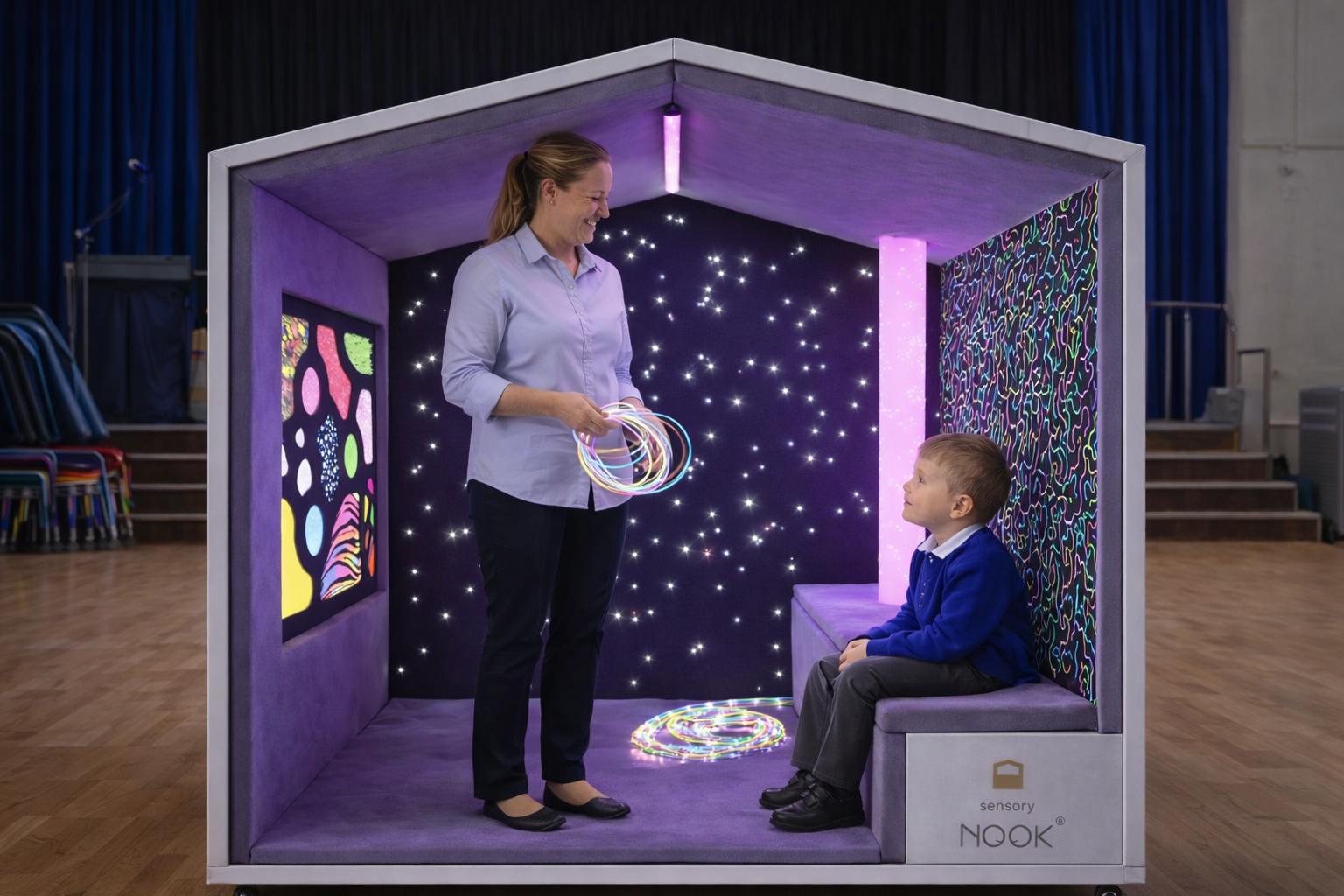 A teacher and a child are stood inside the Sensory Nook Glow.