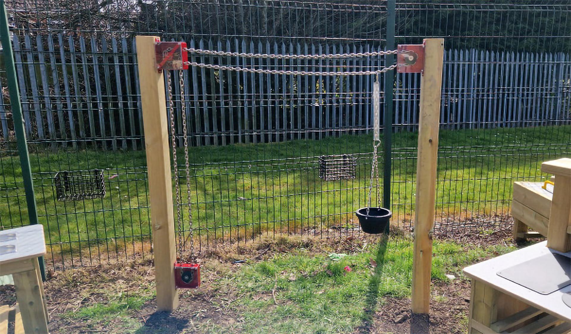 A Chain and Pulley Materials Mover installed on a grass surface.