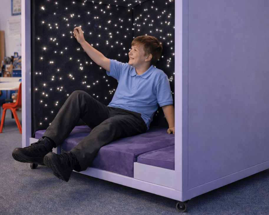 A teenage SEN boy is feeling the material of the inside of the Sensory Nook Retreat.