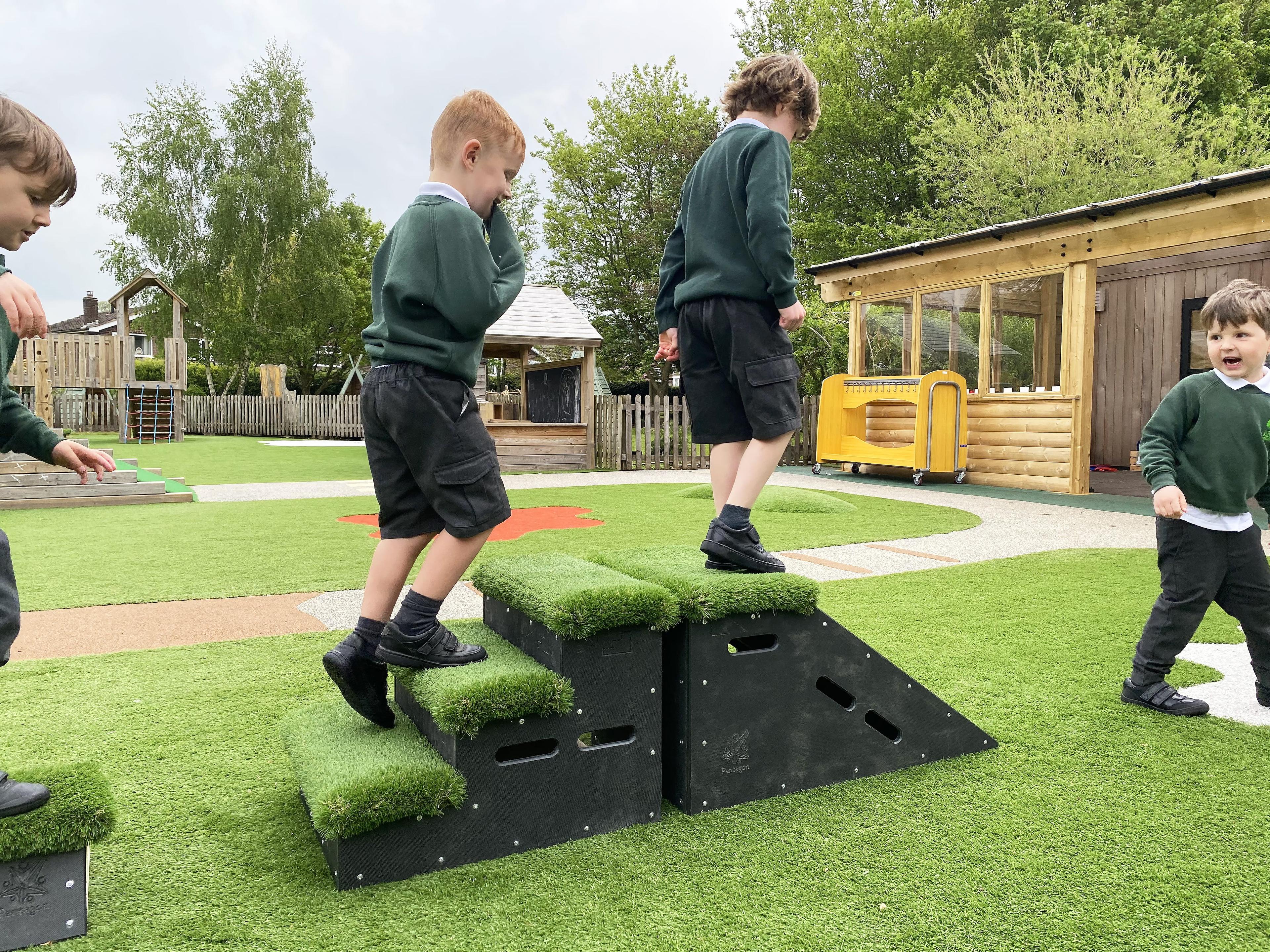 Two boys climbing up stair blocks