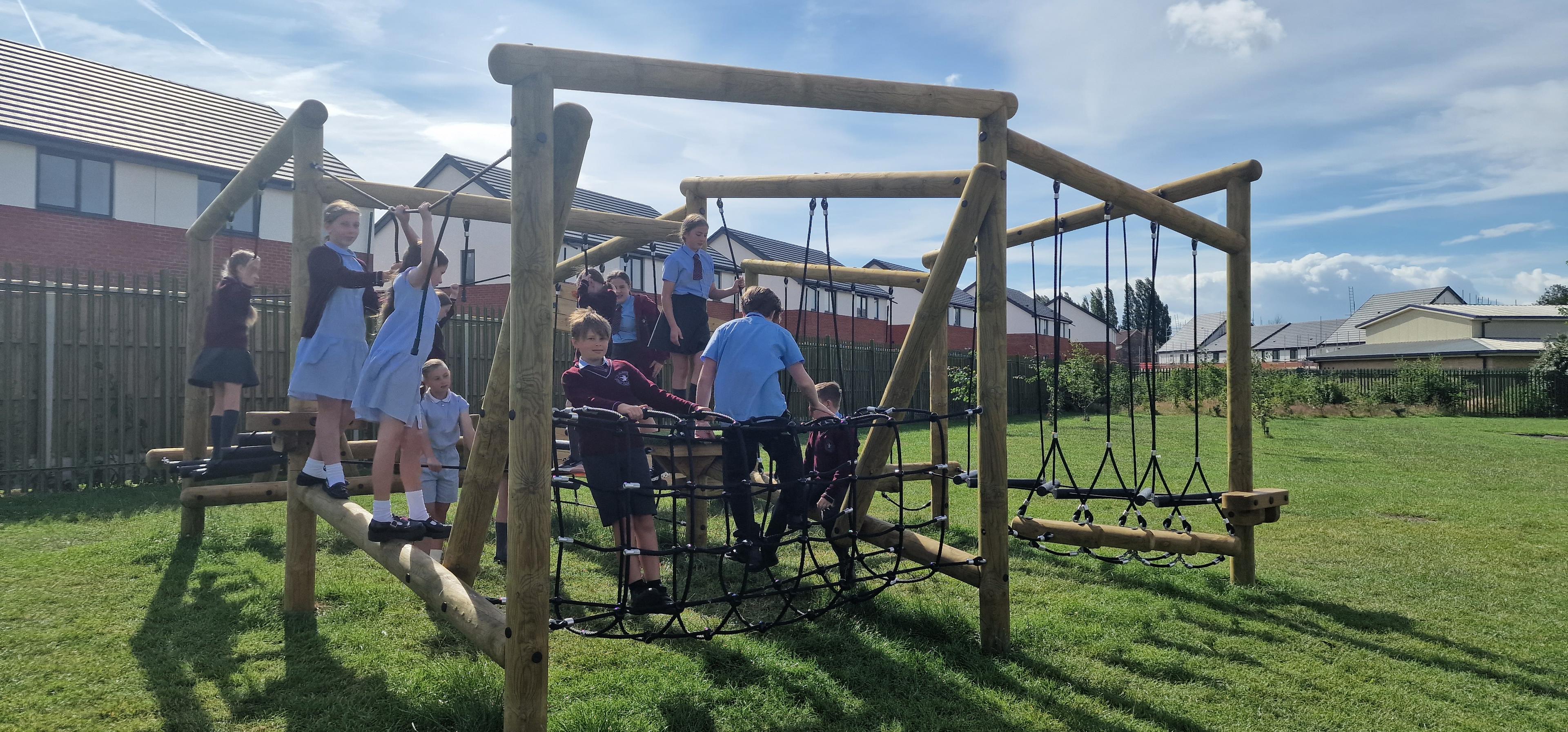 Primary school children using the climbing frame in the playground