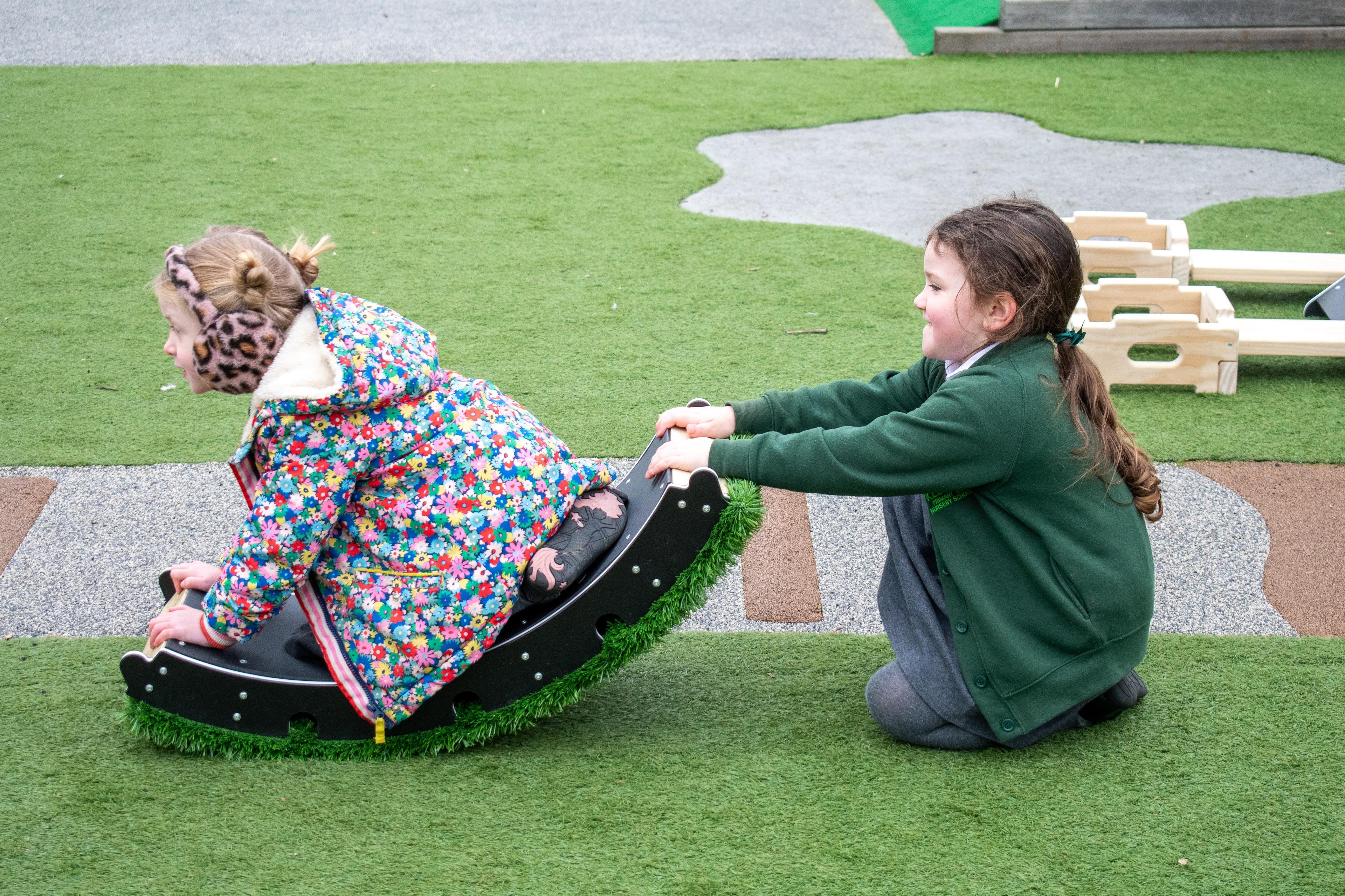 Two children playing on the rocker blocks that make up part of the rockies