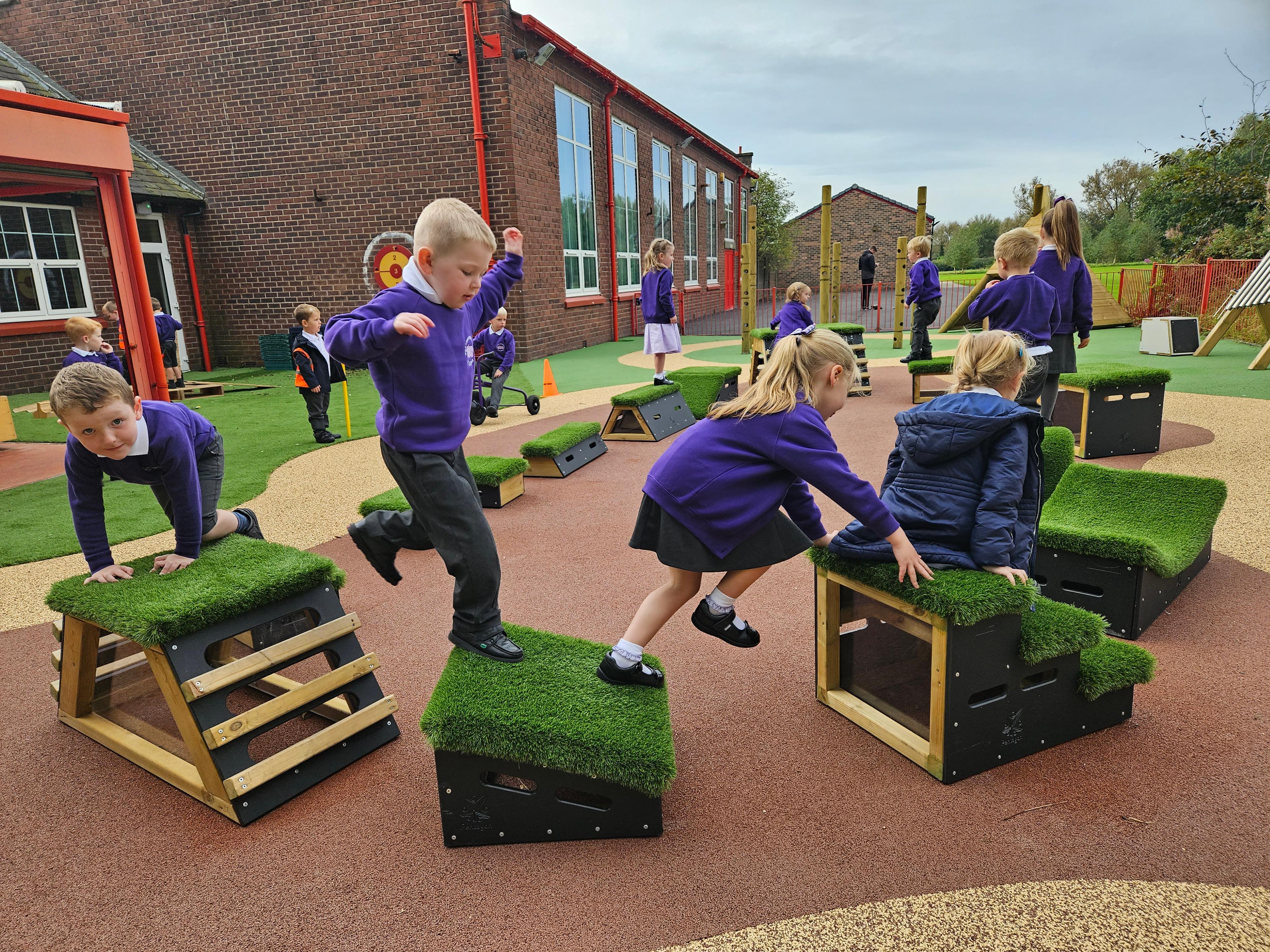 Primary School children playing out outside on grass-topped Get Set, Go! Blocks - Cheviot Set.