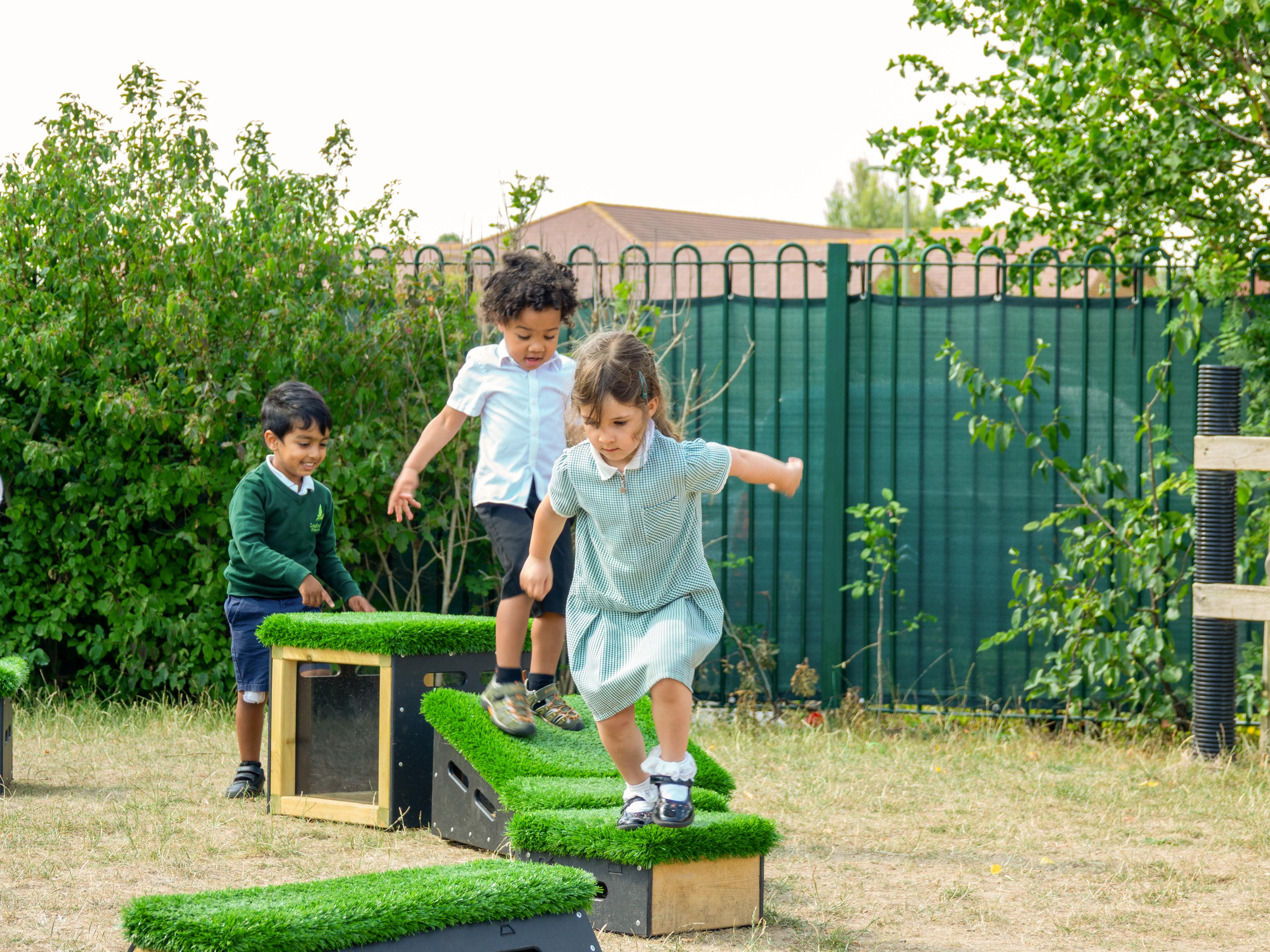 3 children jumping between blocks