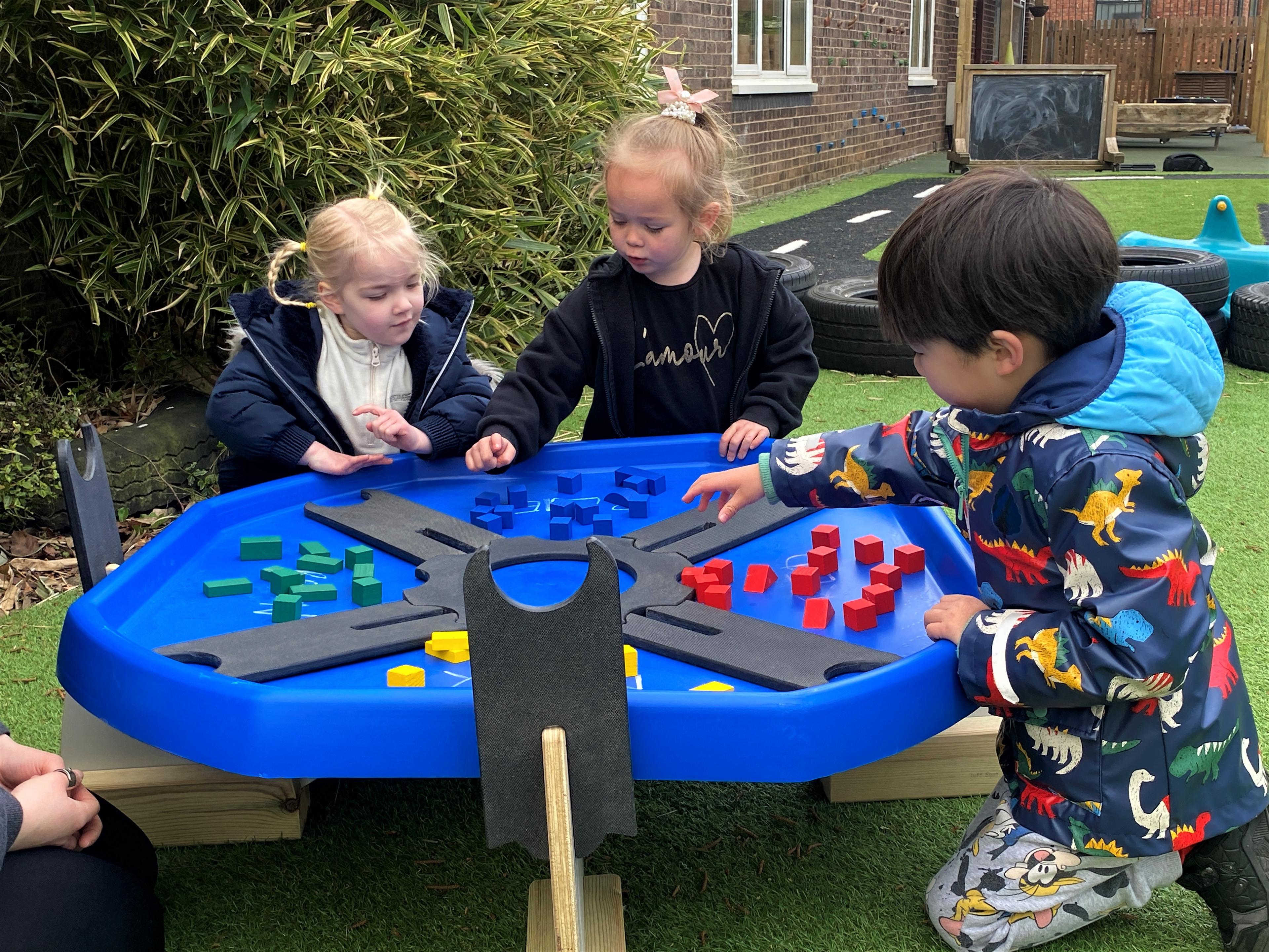 Children playing with a Pentagon Tuff Spot Table