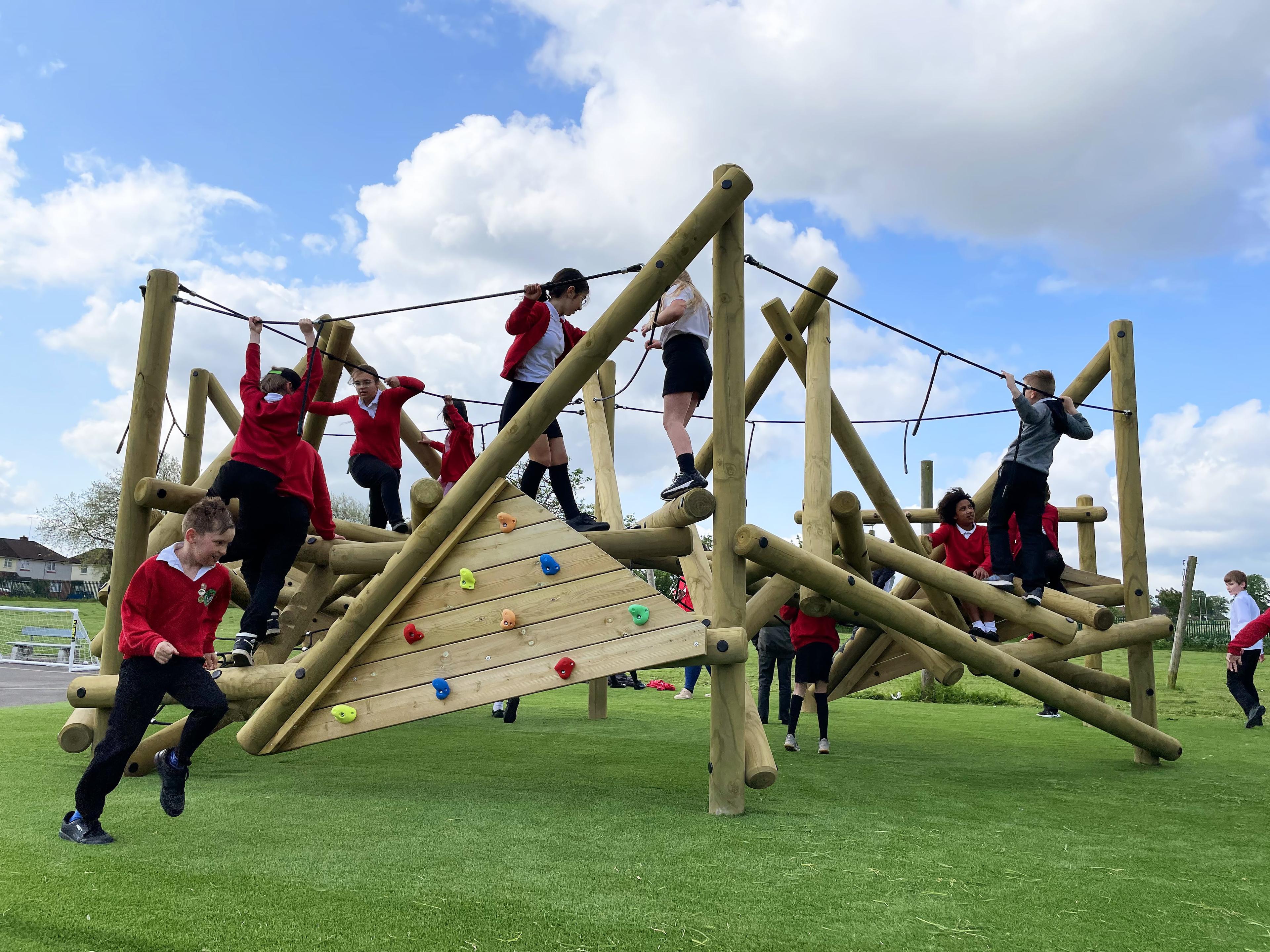A large group of children are playing on the Crinkle Crags Climber with Platform and Climbing Net.