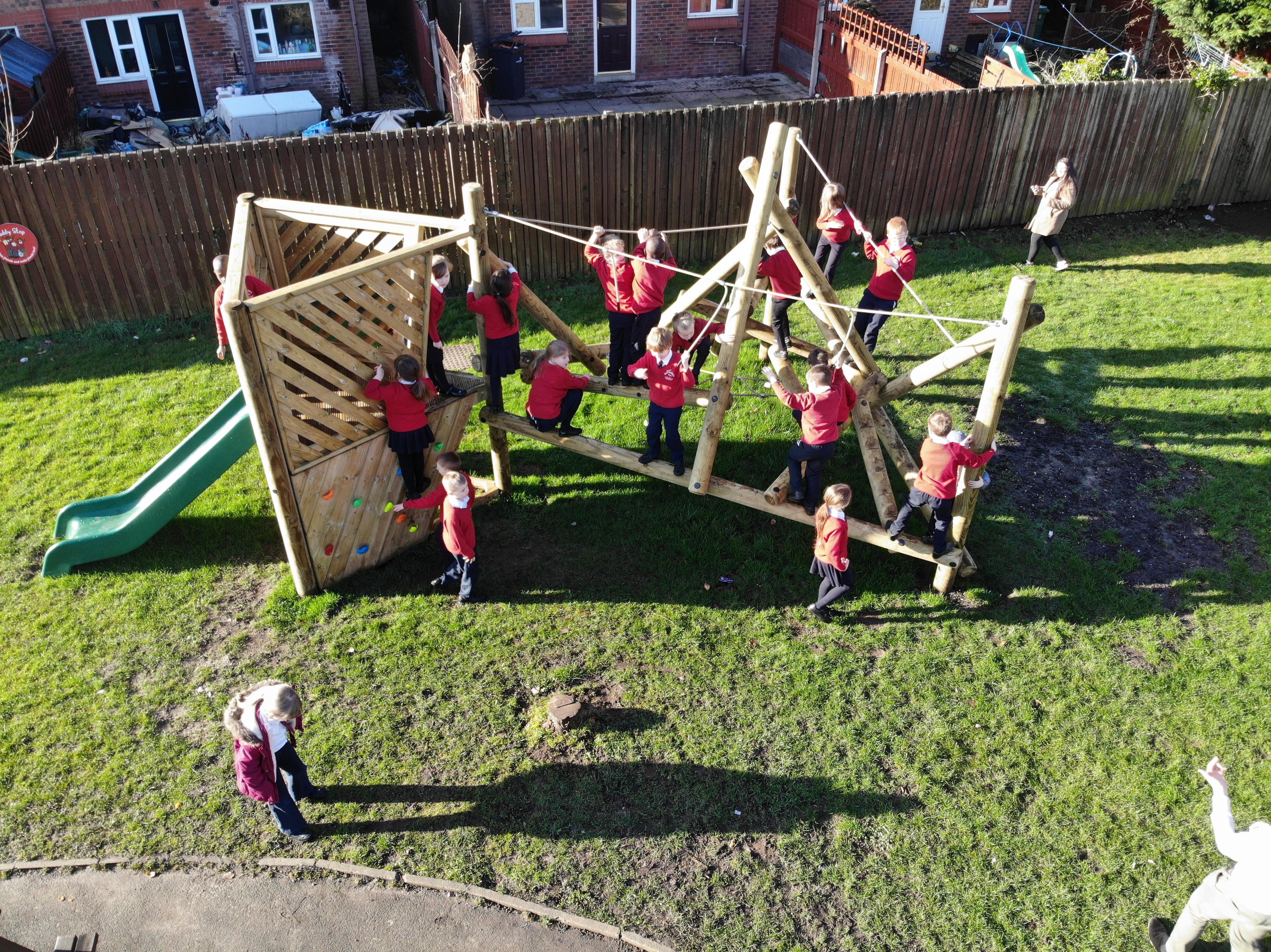 Wooden Bowfell Climbing Frame with Platform and Slide in school playground.