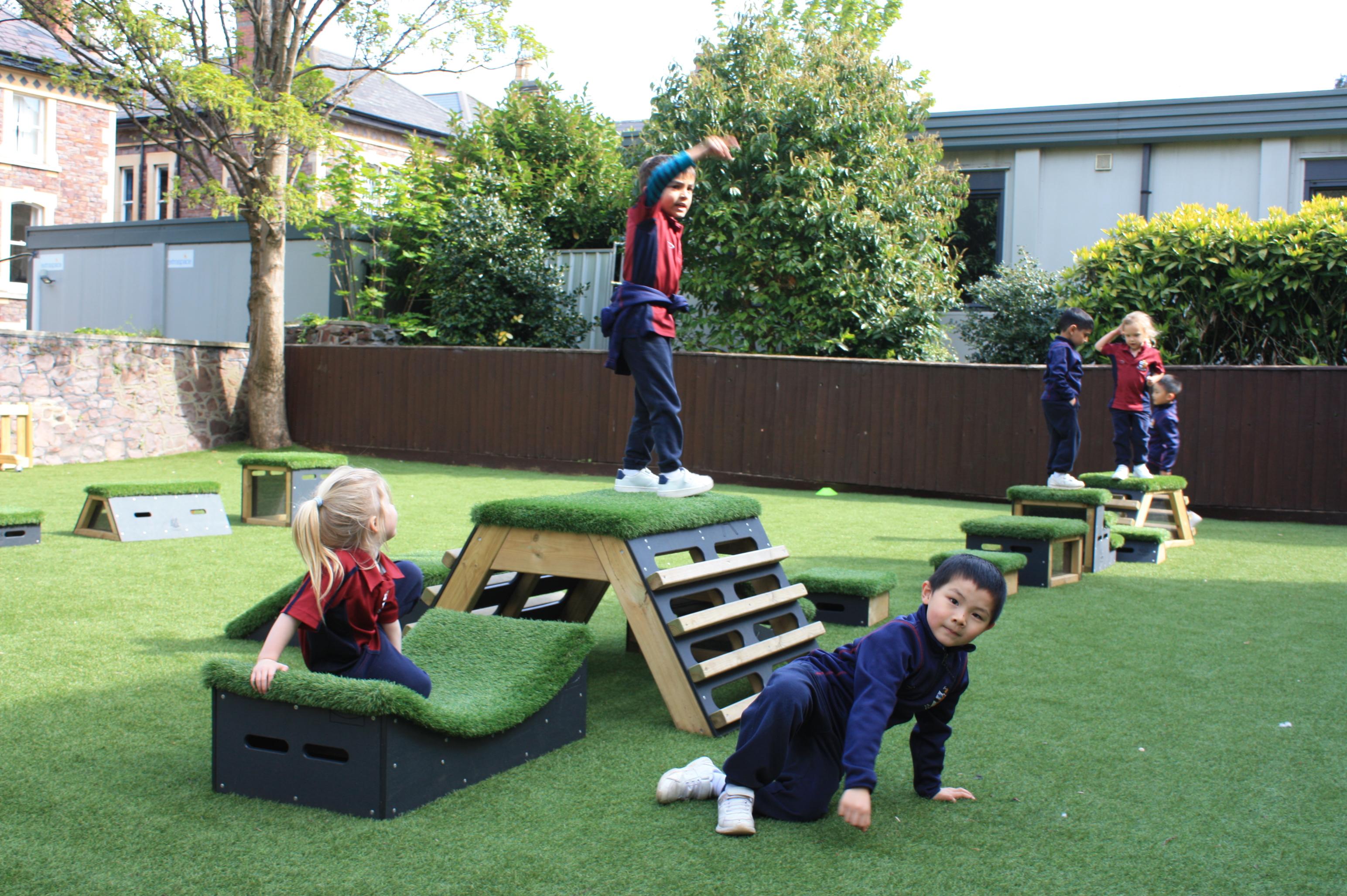 Primary School children playing out outside on grass-topped Get Set, Go! Blocks - Cheviot Set.