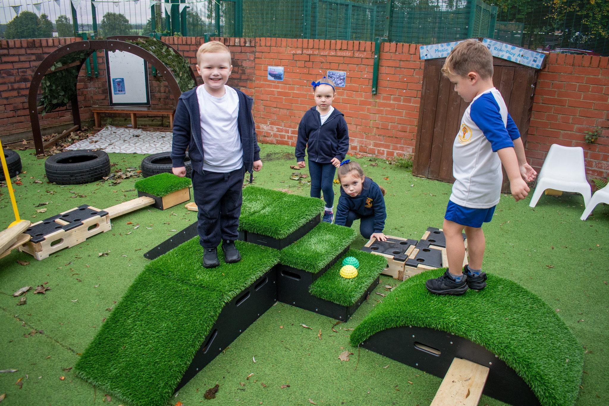 A group of EYFS children stood on Get Set Go Blocks and Play Builder.