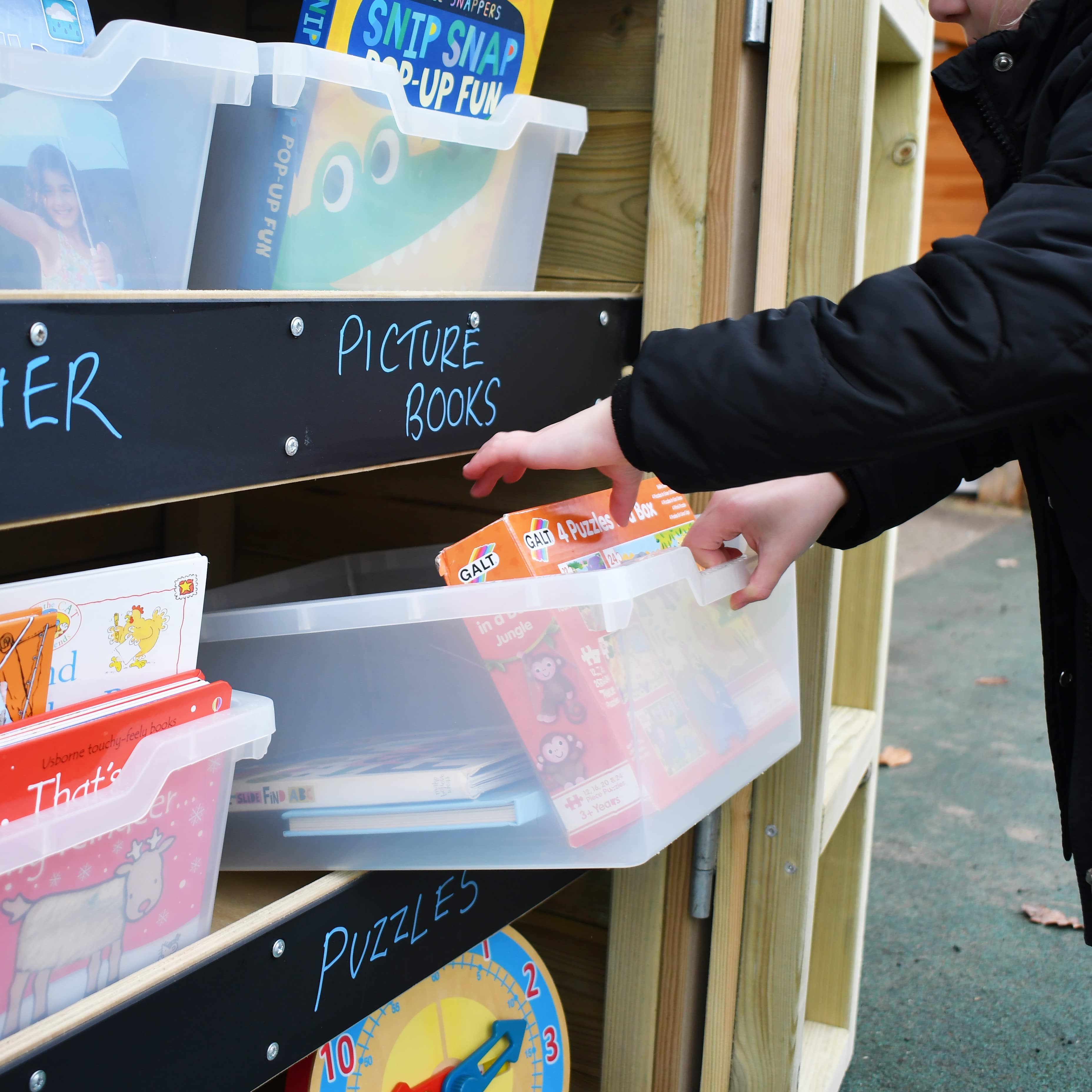 An open wooden Acorn Storage Unit with school resources inside, in a school playground