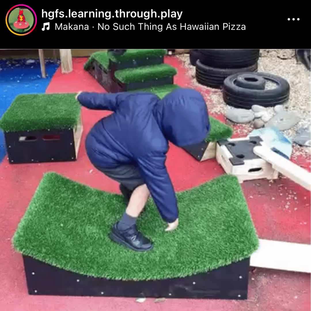 A little boy is balancing on a dipped block from the Cheviot Set.