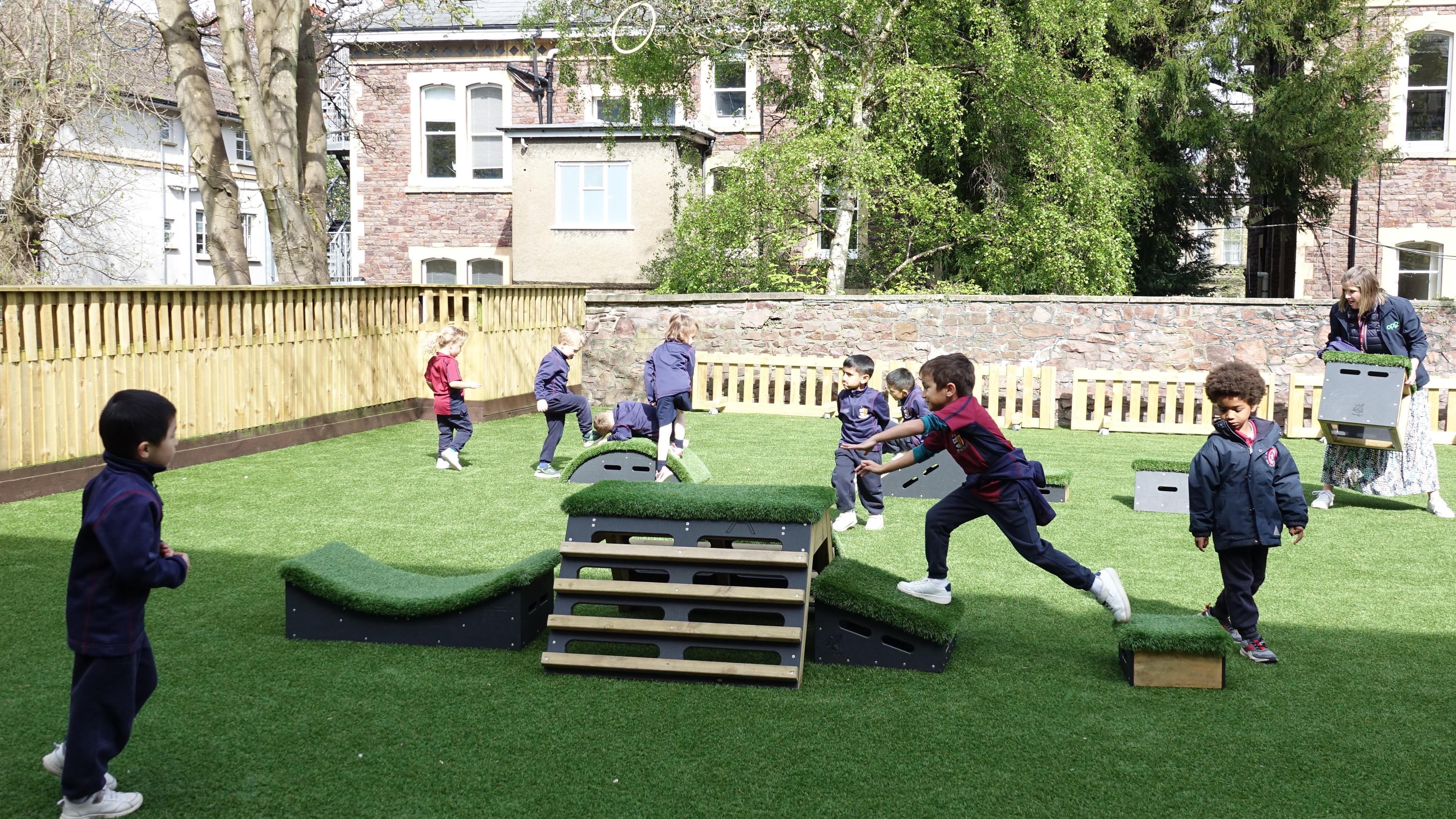 Primary School children playing out outside on grass-topped Get Set, Go! Blocks - Cheviot Set.