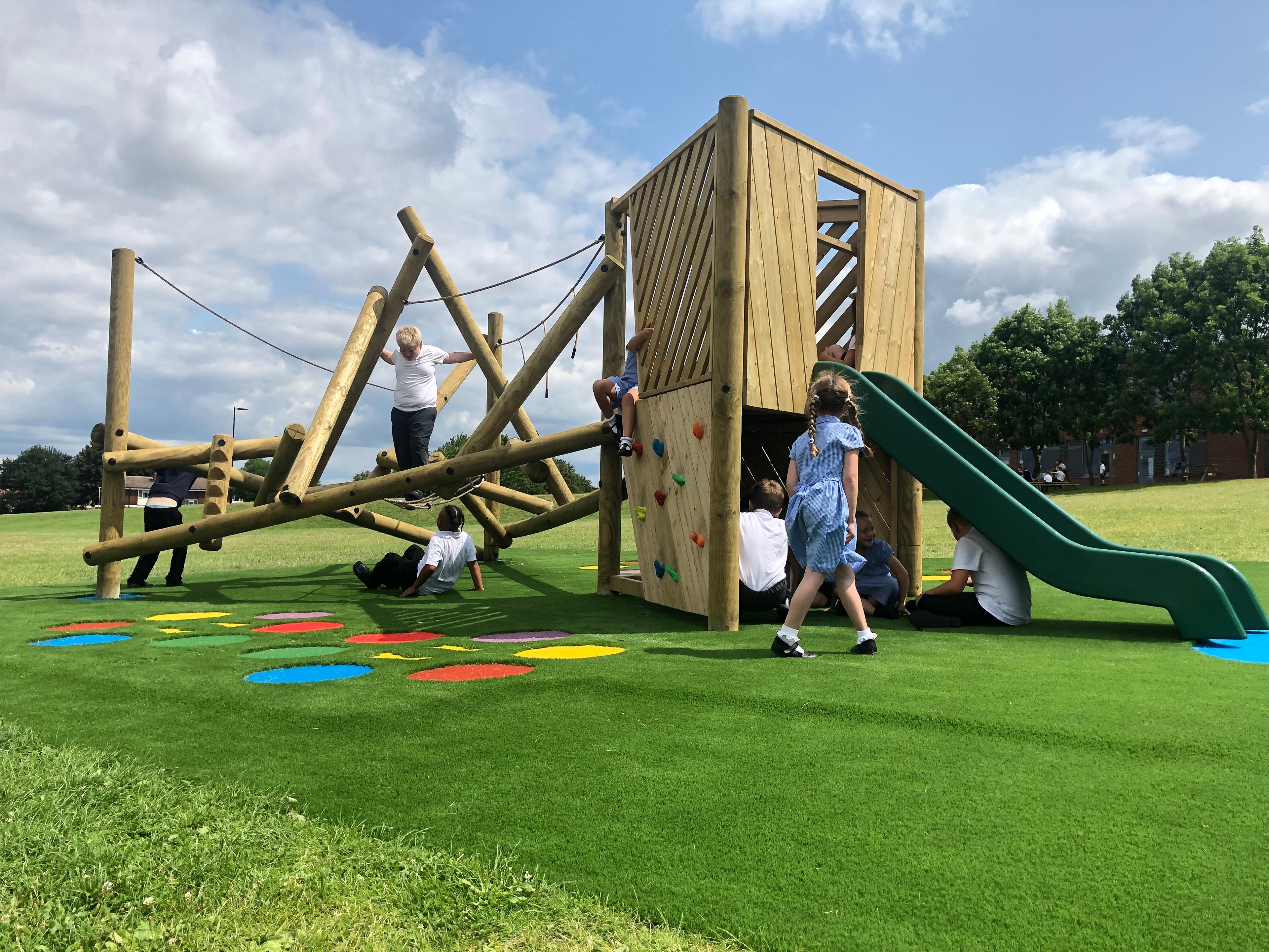 Wooden Bowfell Climbing Frame with Platform and Slide in school playground.