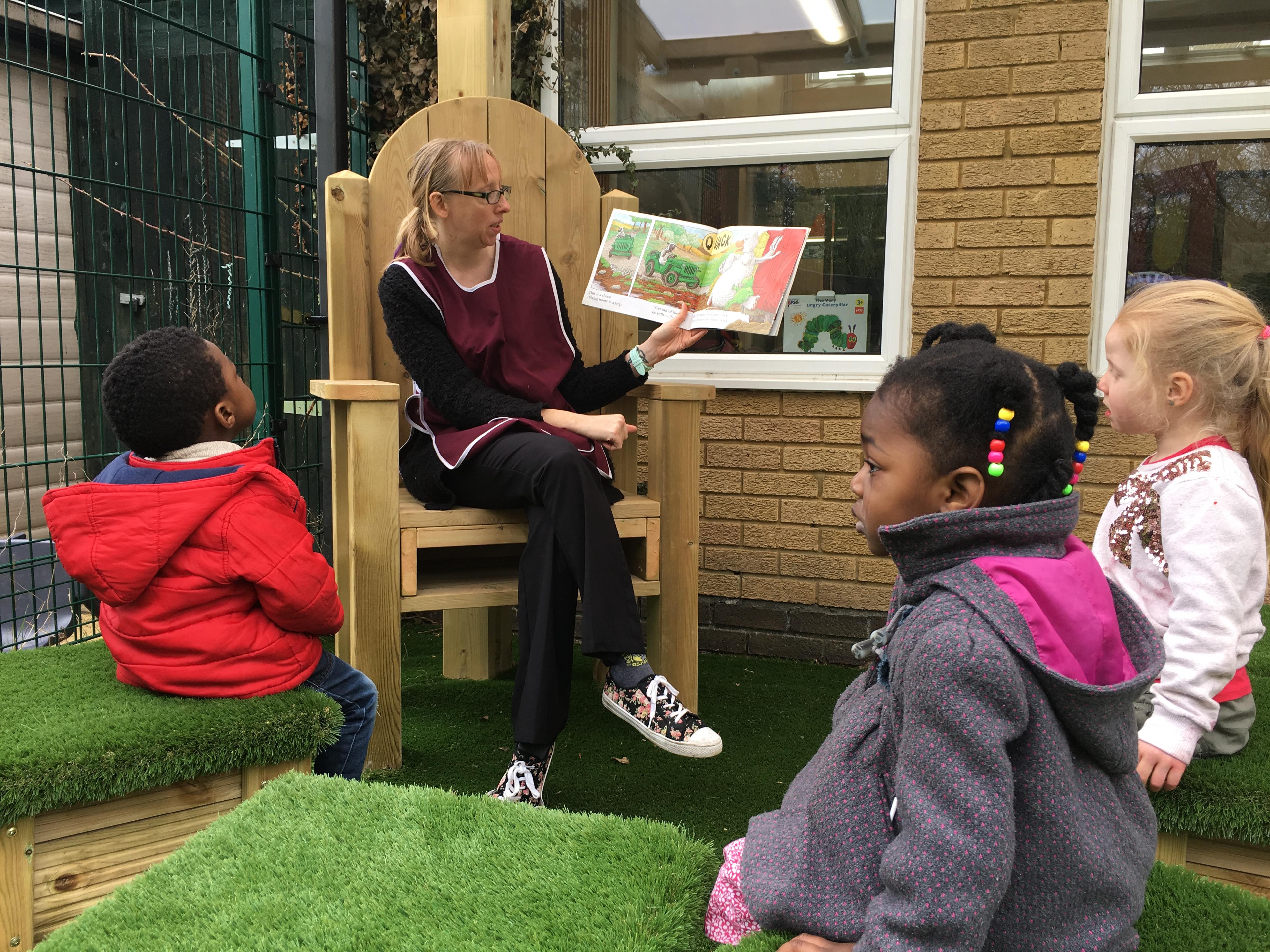 A teacher reading a story on the story telling chair