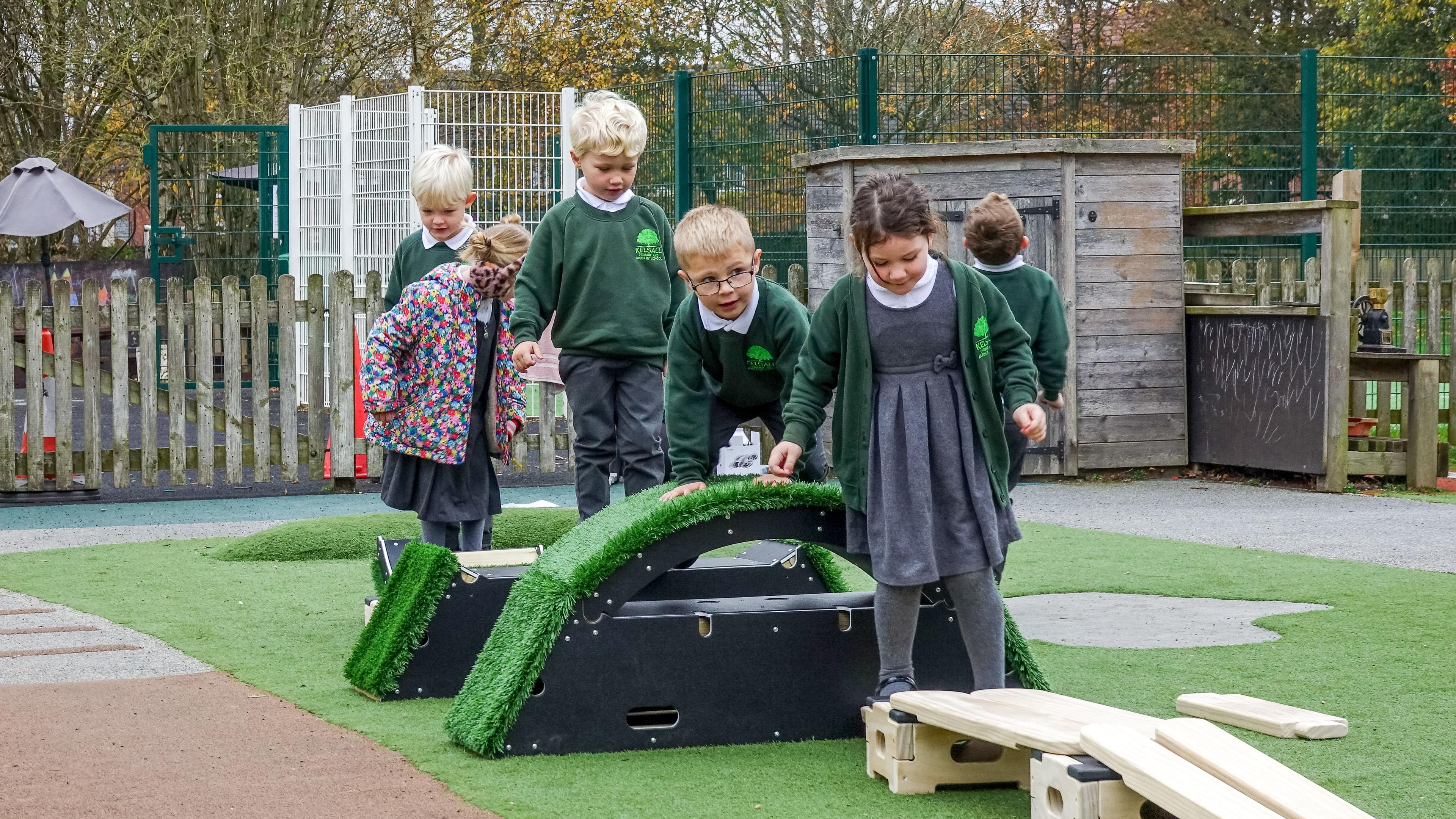 A line of children are navigating an obstacle course made from Get Set Go blocks and Play Builder.
