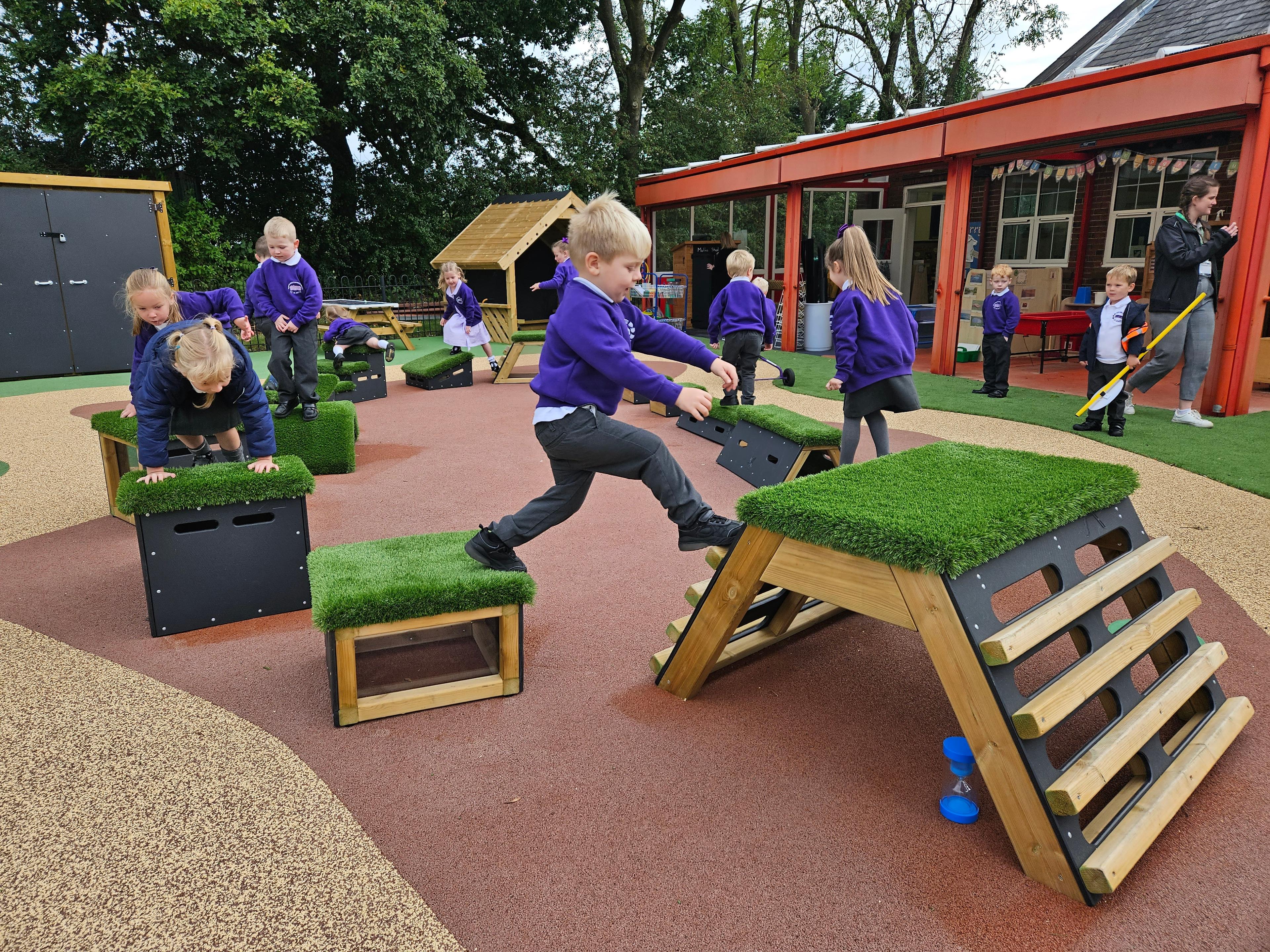 Primary School children playing out outside on grass-topped Get Set, Go! Blocks - Cheviot Set.