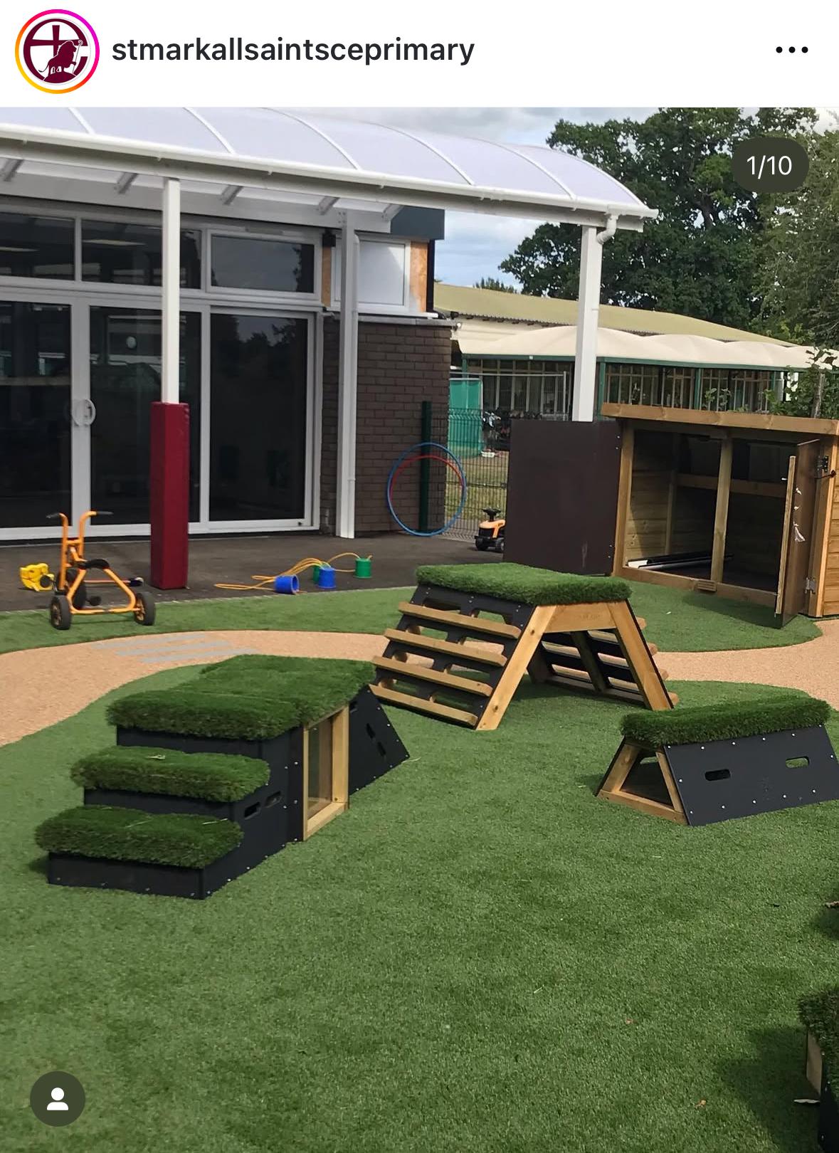 Three blocks from the Cheviot set are placed on an artificial grass surface outside of a school building.