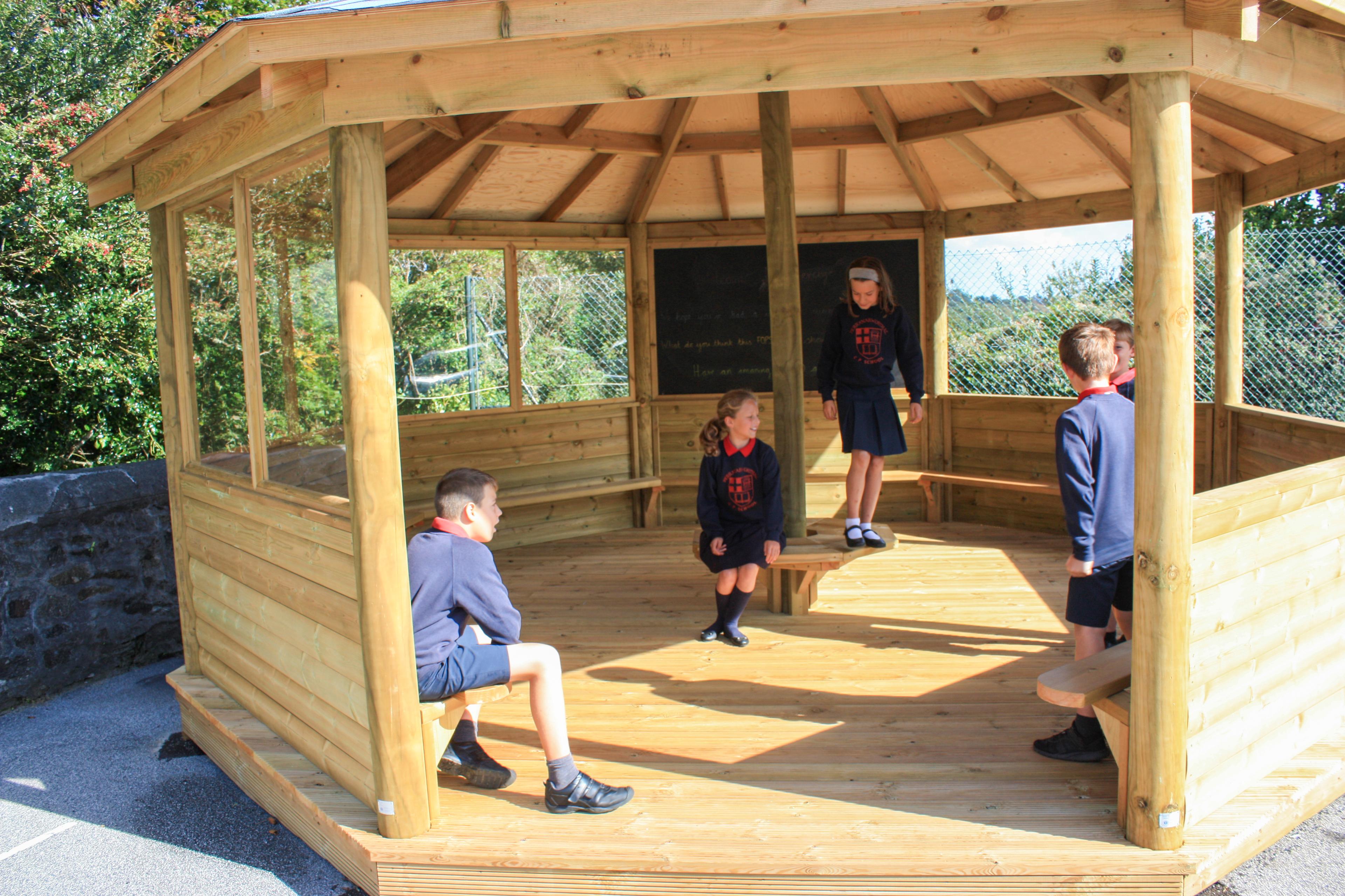 Wooden 6m Octagonal Gazebo with decked base in a school playground.