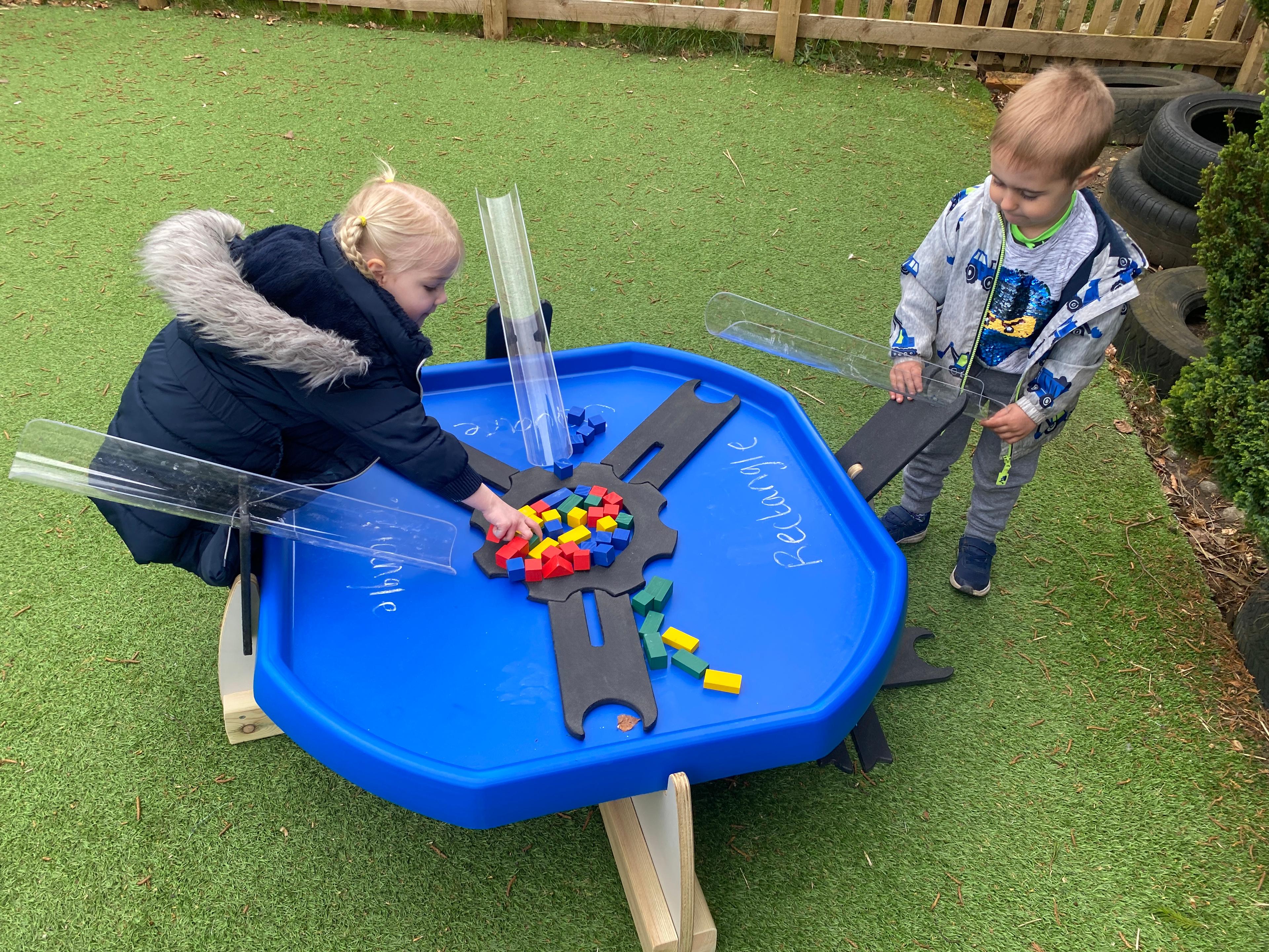Children playing with a Pentagon Tuff Spot Table