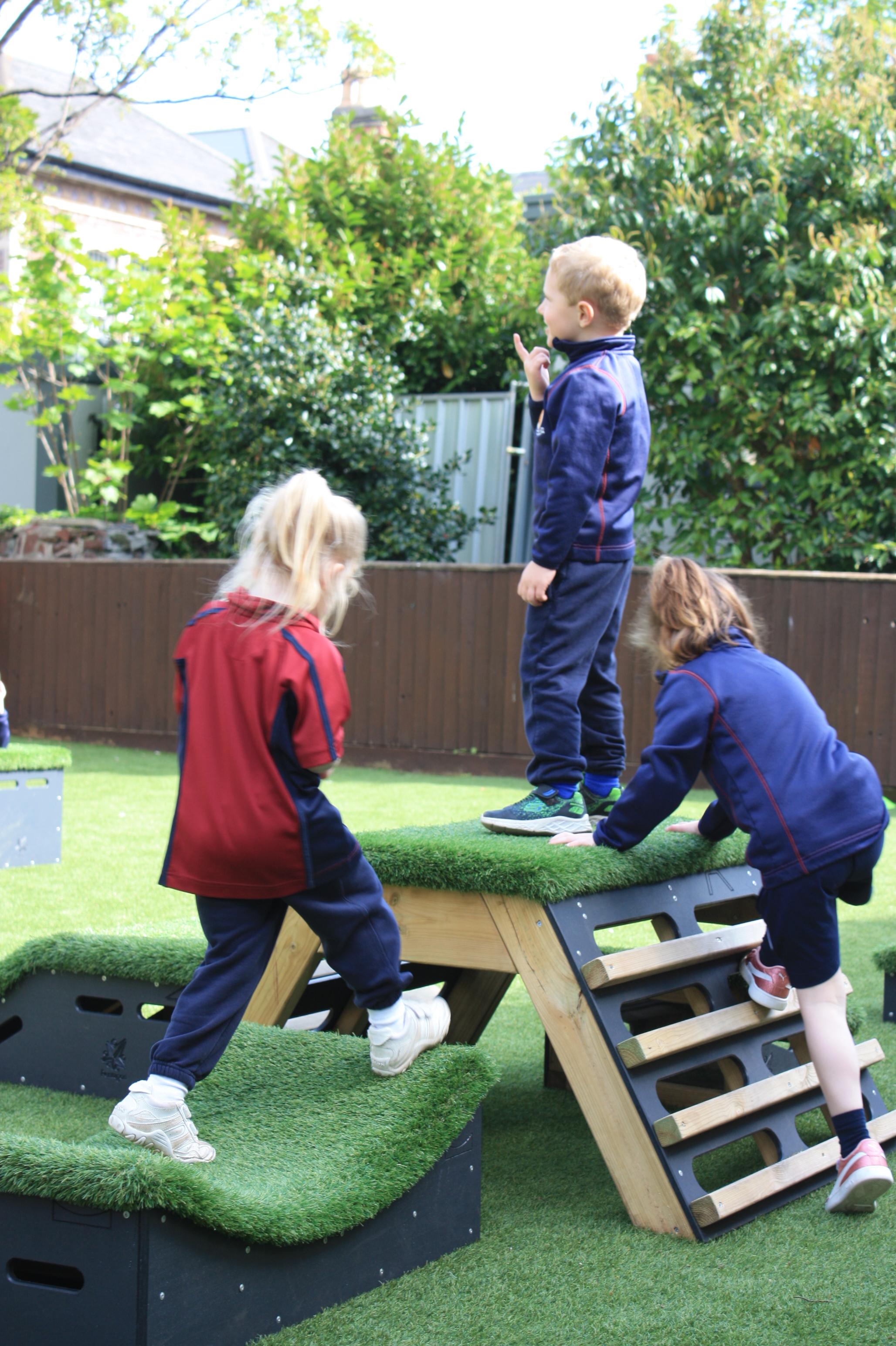 Primary School children playing out outside on grass-topped Get Set, Go! Blocks - Cheviot Set.
