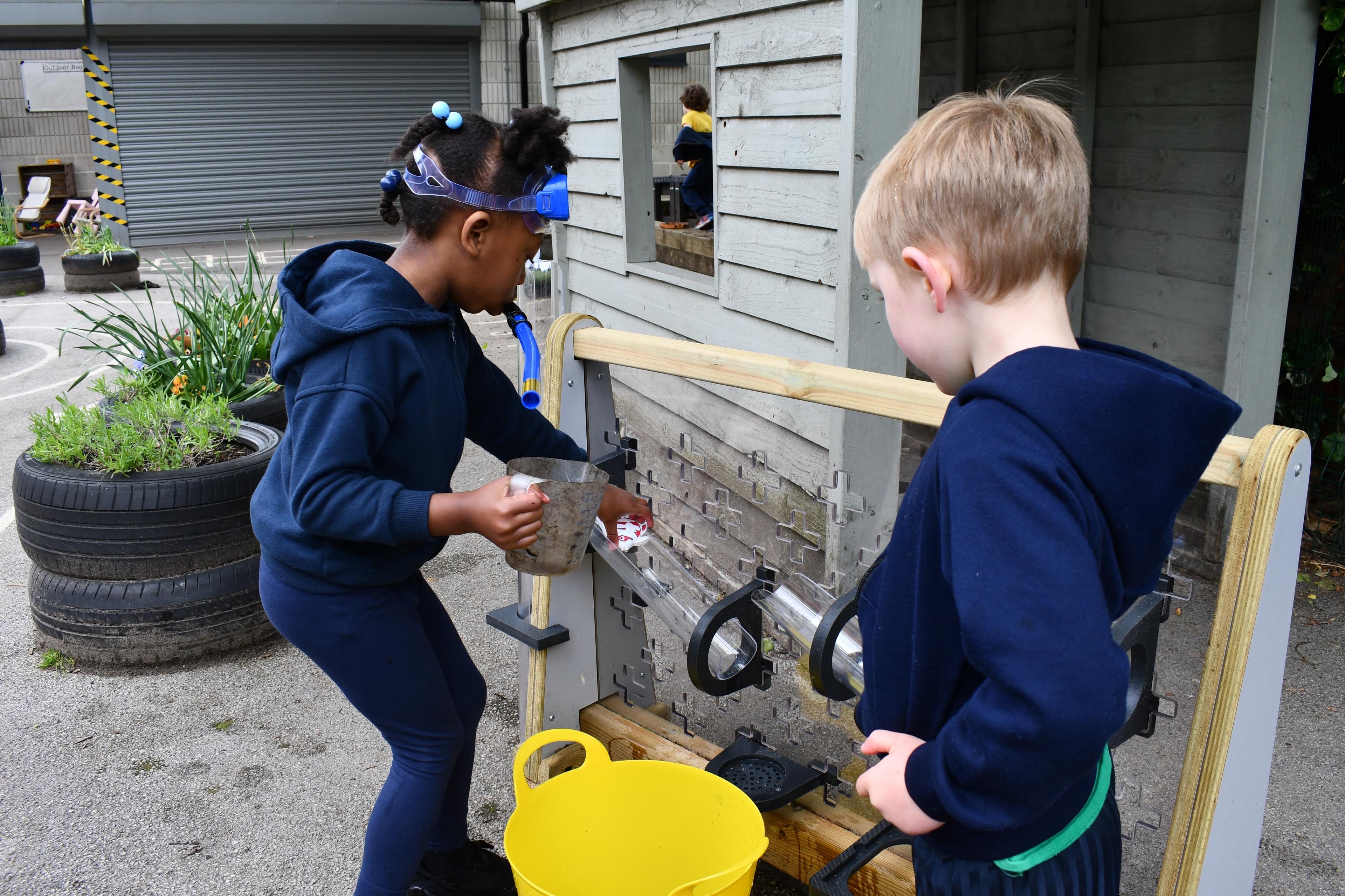 Children playing with a Pentagon Mini Water Wall.
