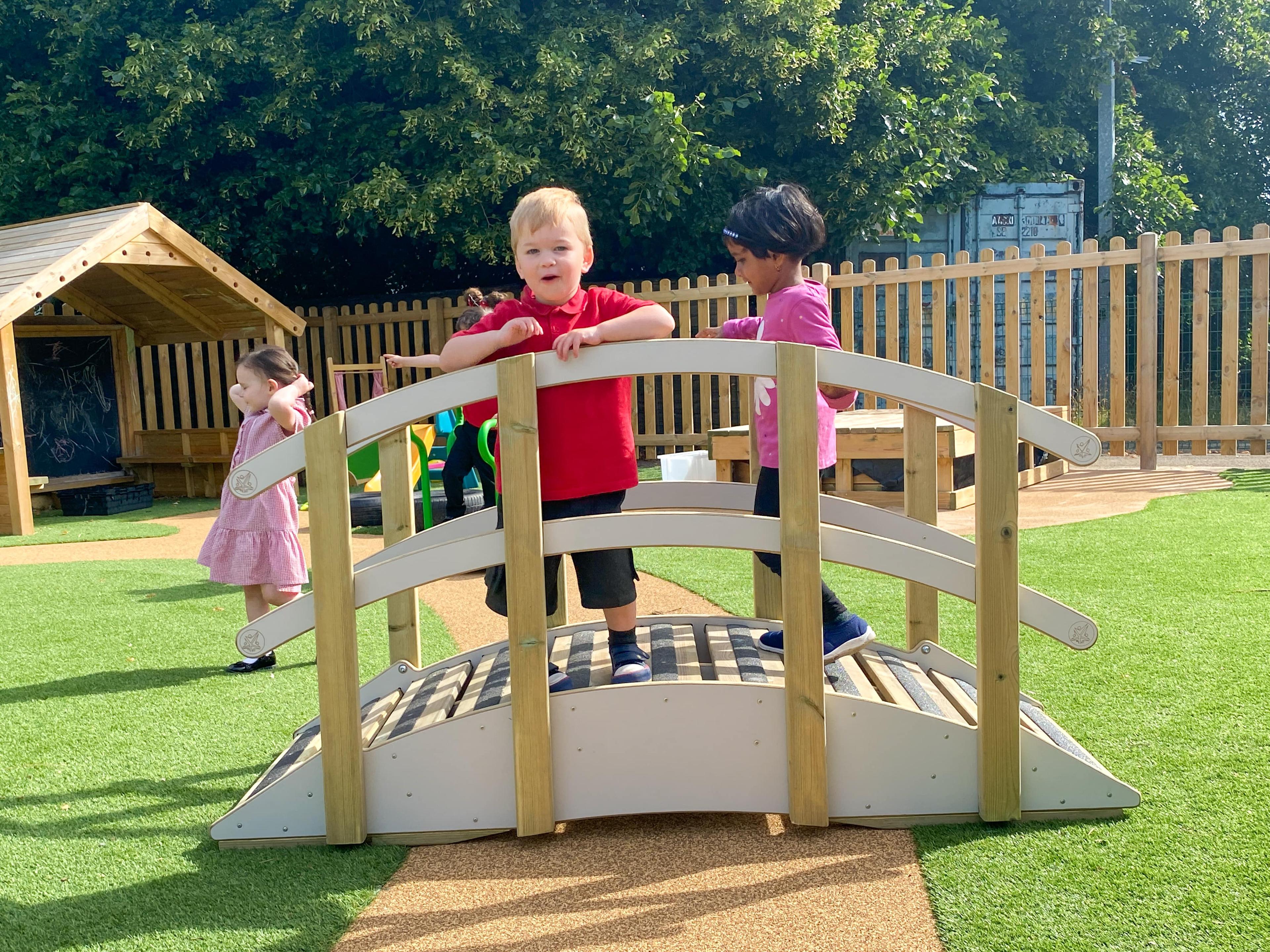 Two children are stood on the Play Bridge with Handrails. The boy is looking at the camera.