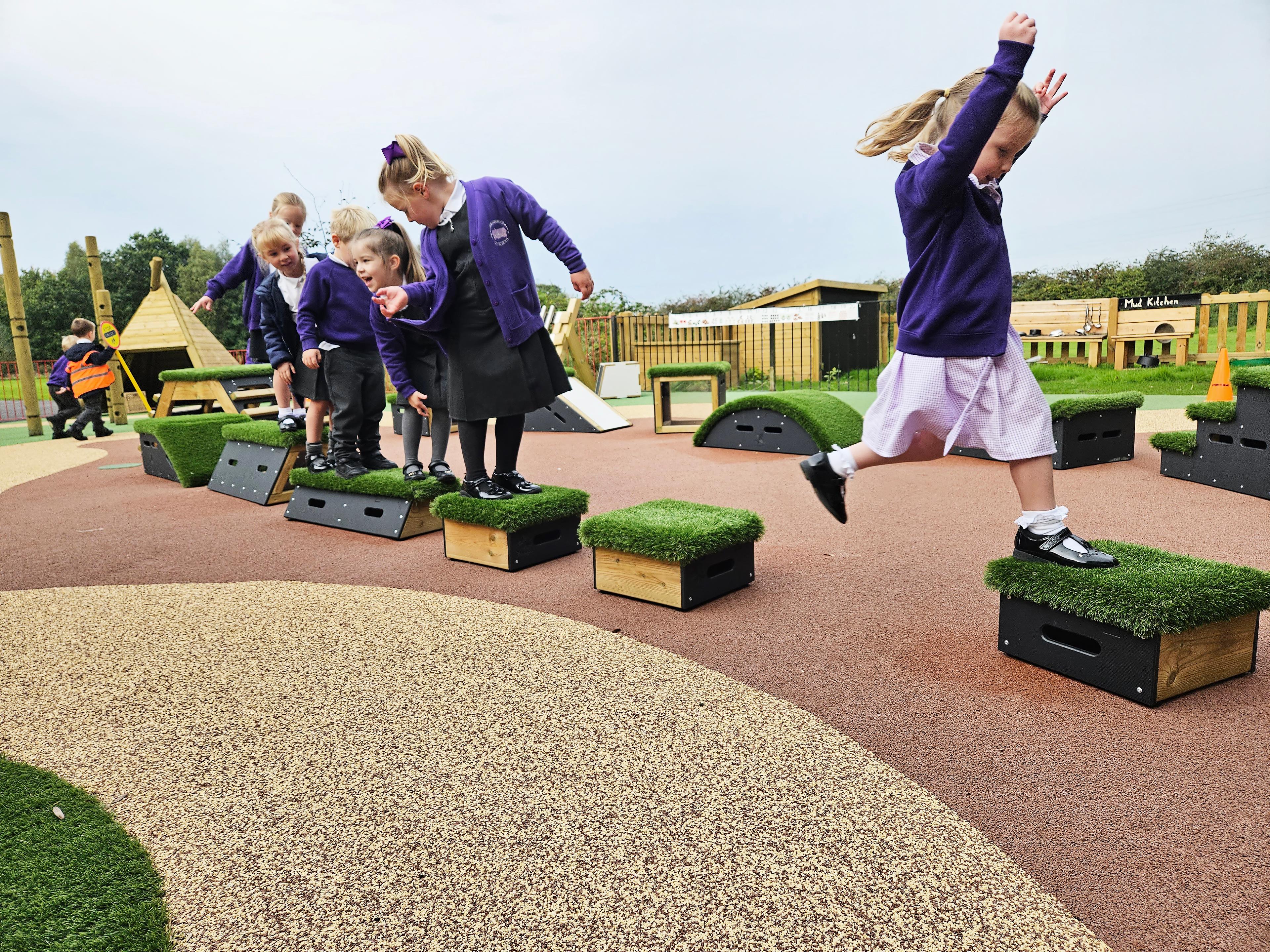 Primary School children playing out outside on grass-topped Get Set, Go! Blocks - Cheviot Set.