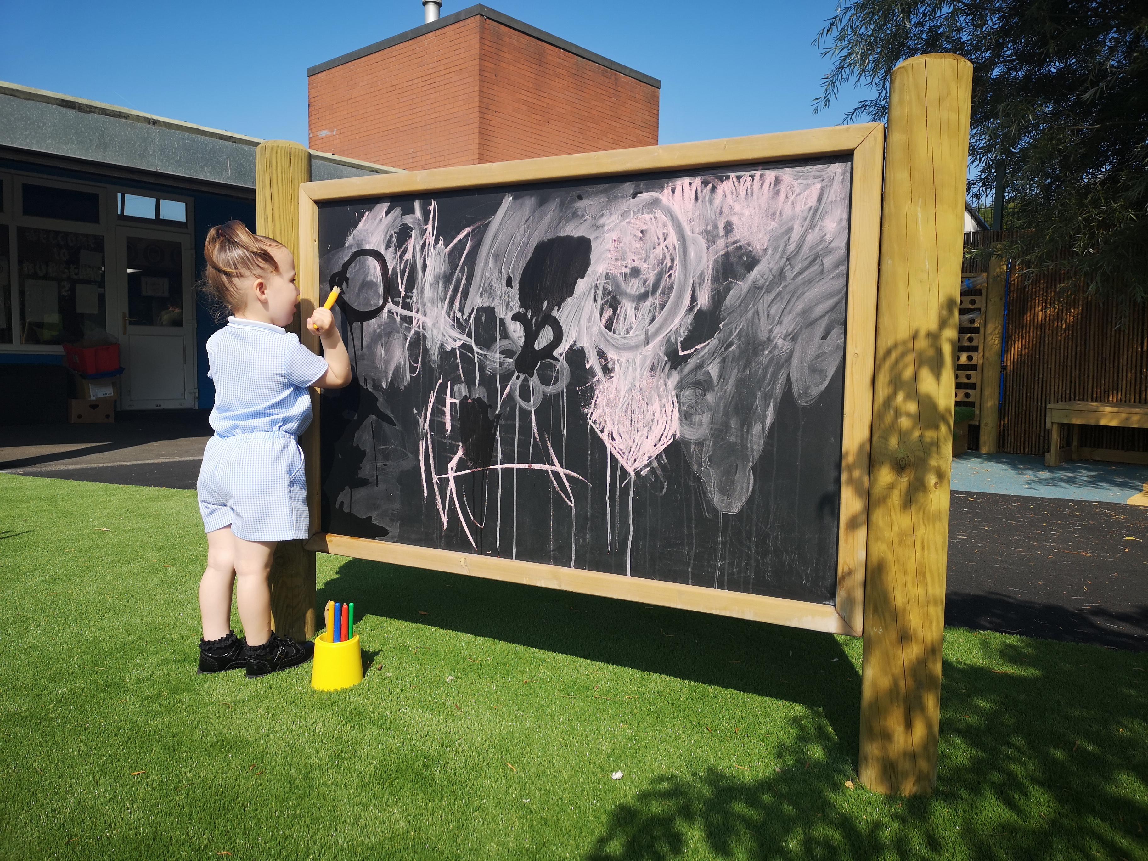 Giant wooden chalkboard on posts from Pentagon Play
