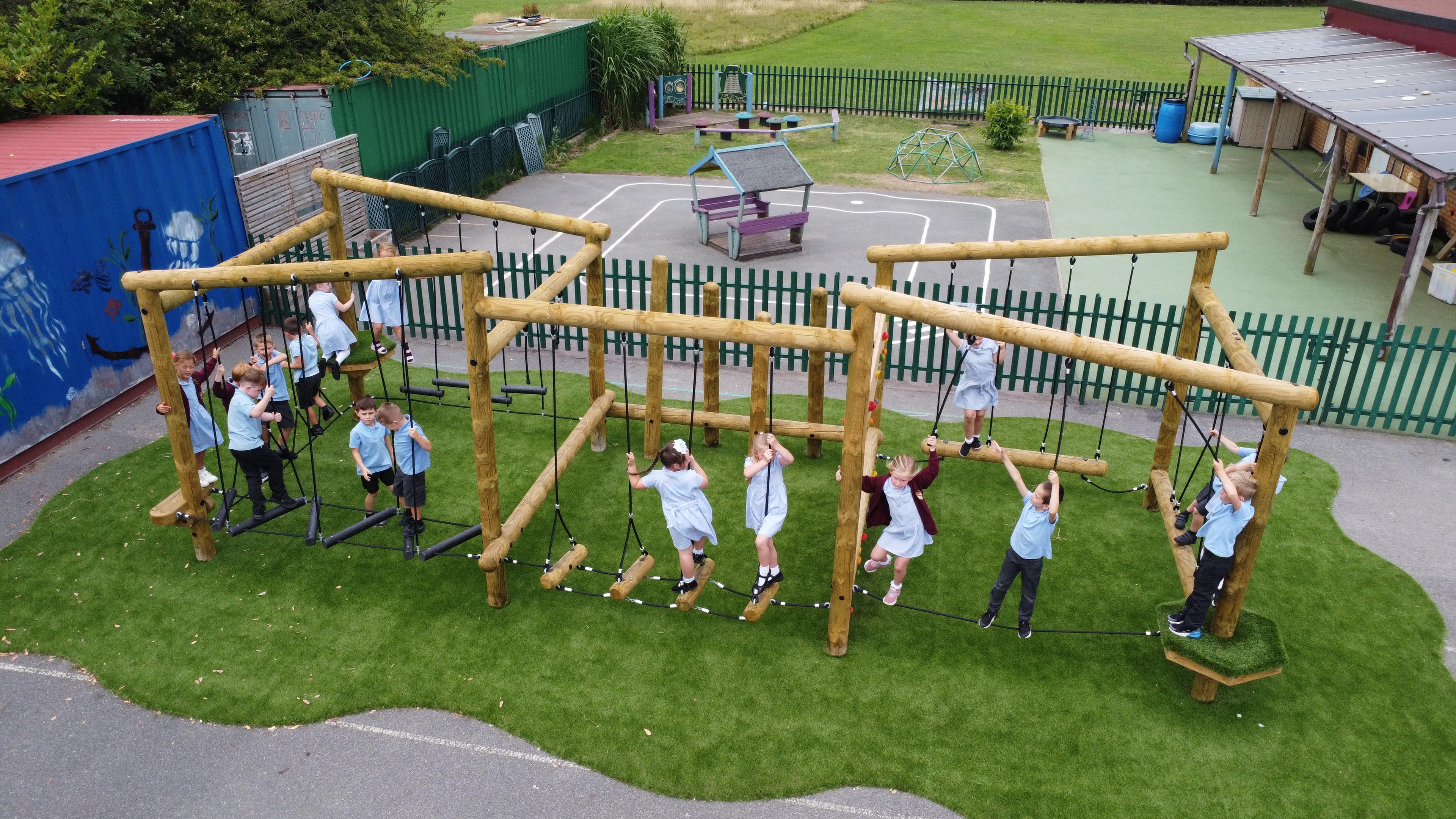Wooden Kielder Forest Circuit Climbing Frame with multiple children playing on it.