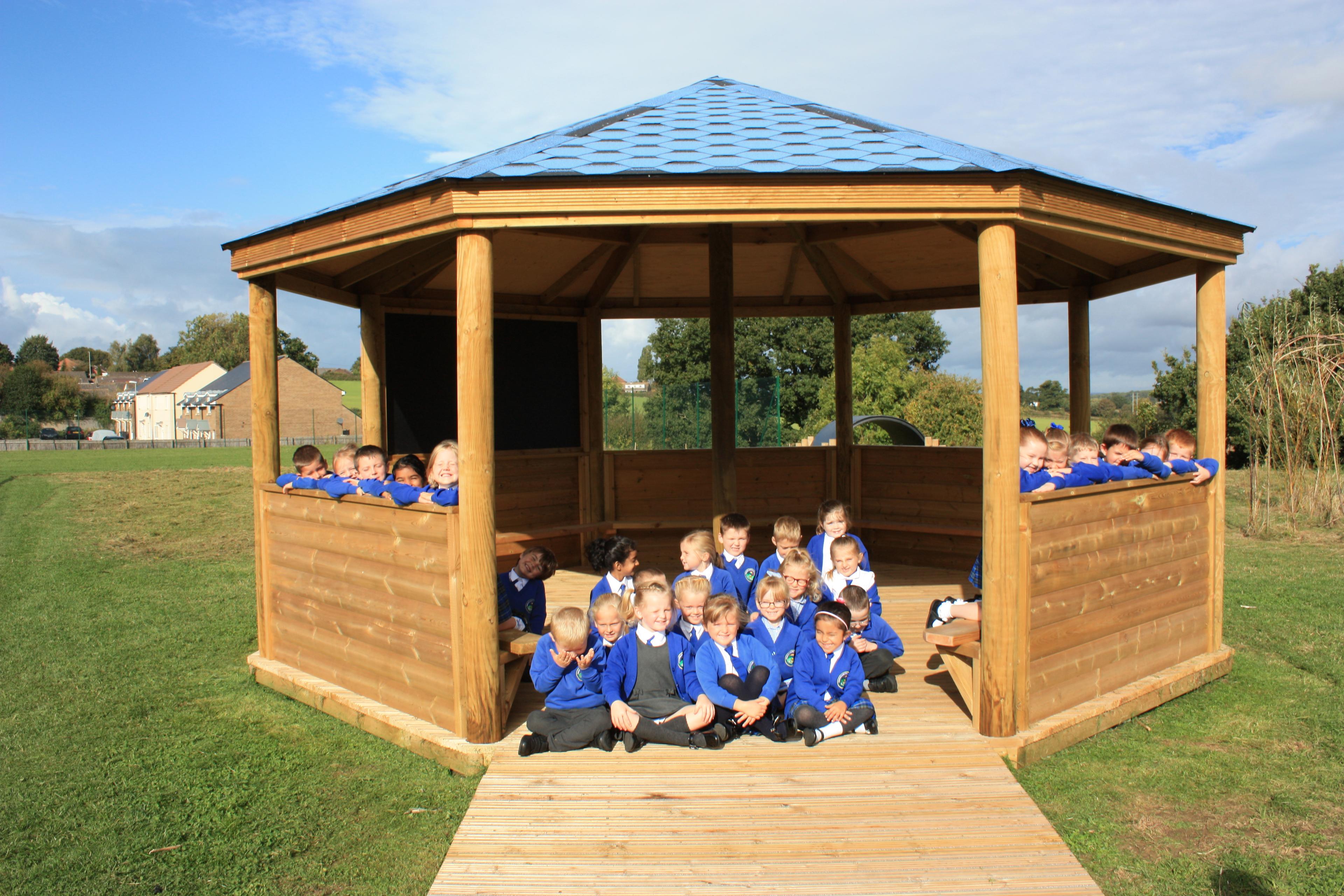 Wooden 6m Octagonal Gazebo with decked base in a school playground.