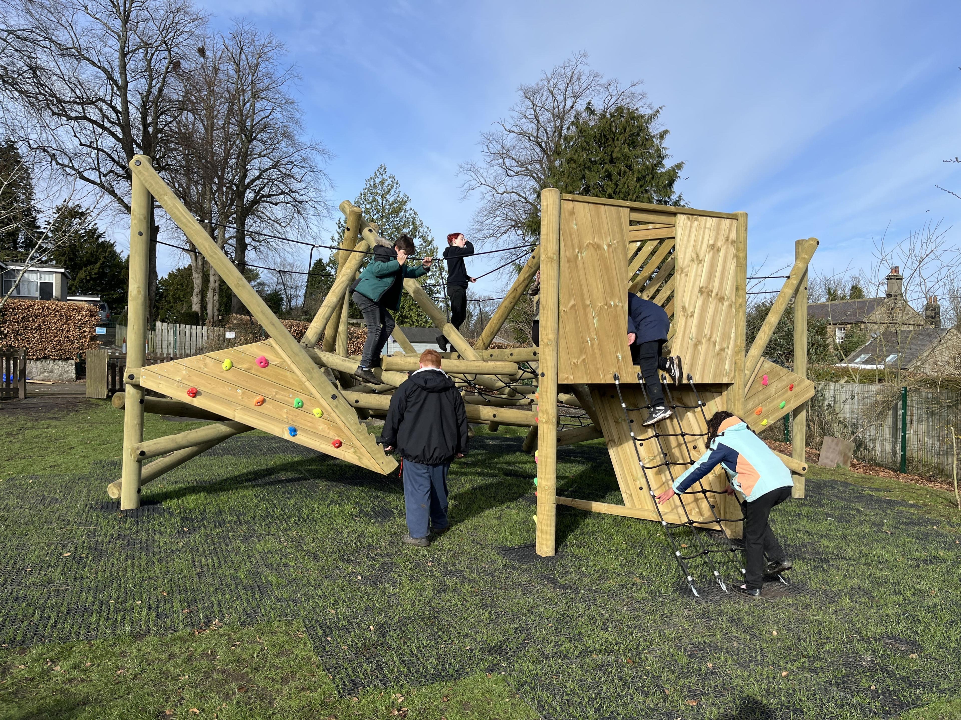A group of children exploring the Crinkle Crags Climber with Platform and Climbing Net.