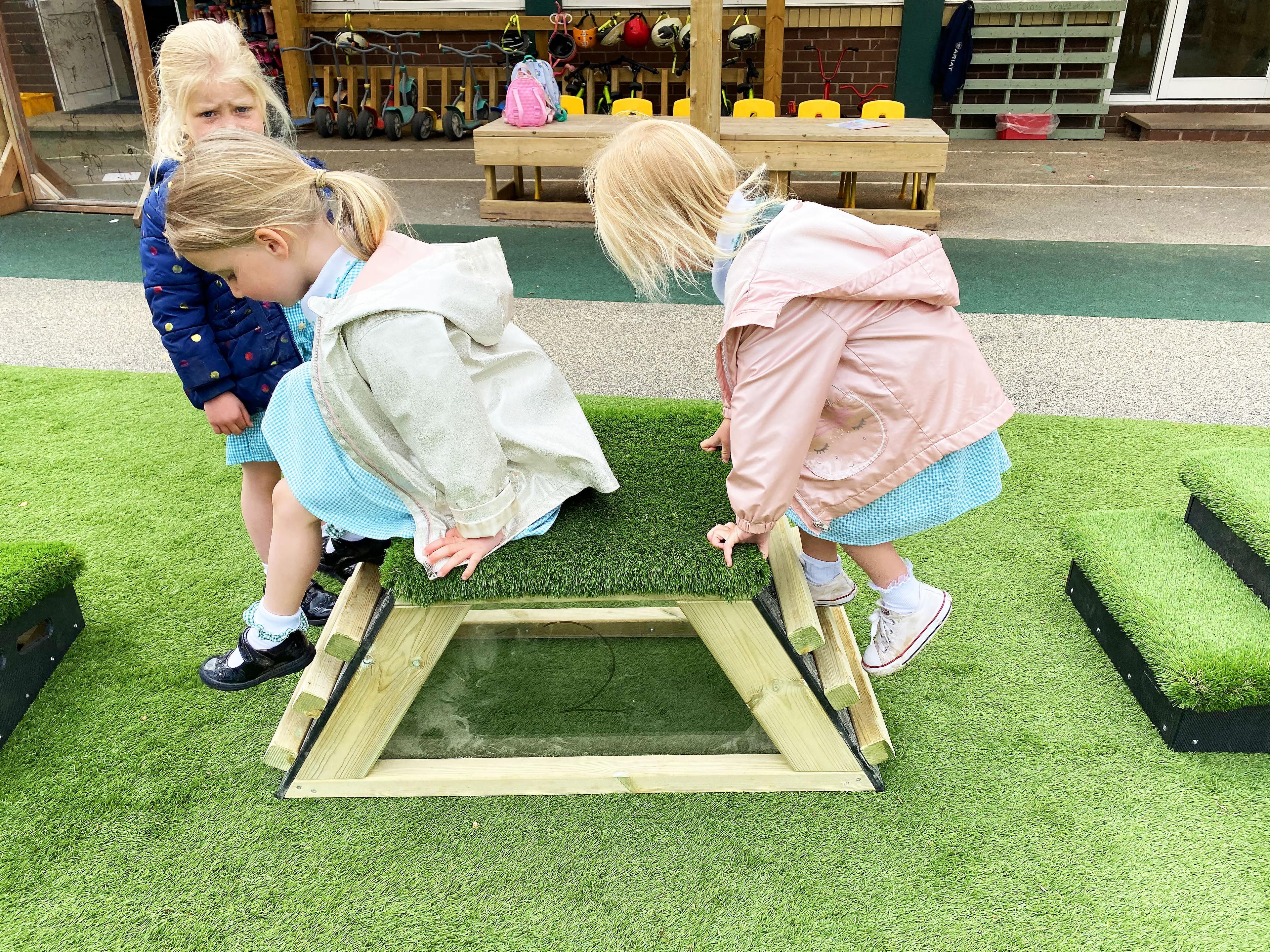 Kids jumping off grass topped block