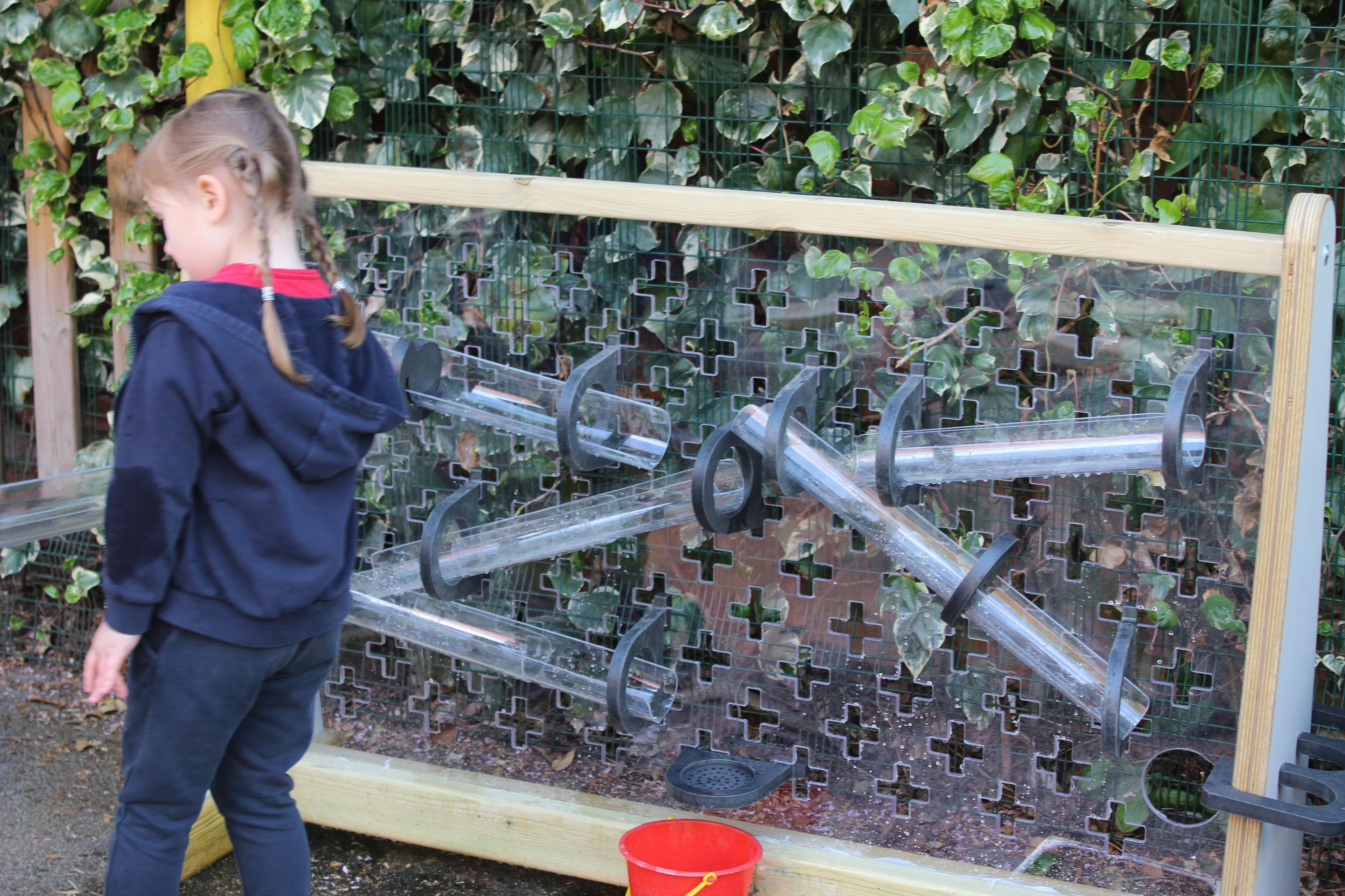 Children playing with the water wall that makes up part of the Pioneer Messy Play Package