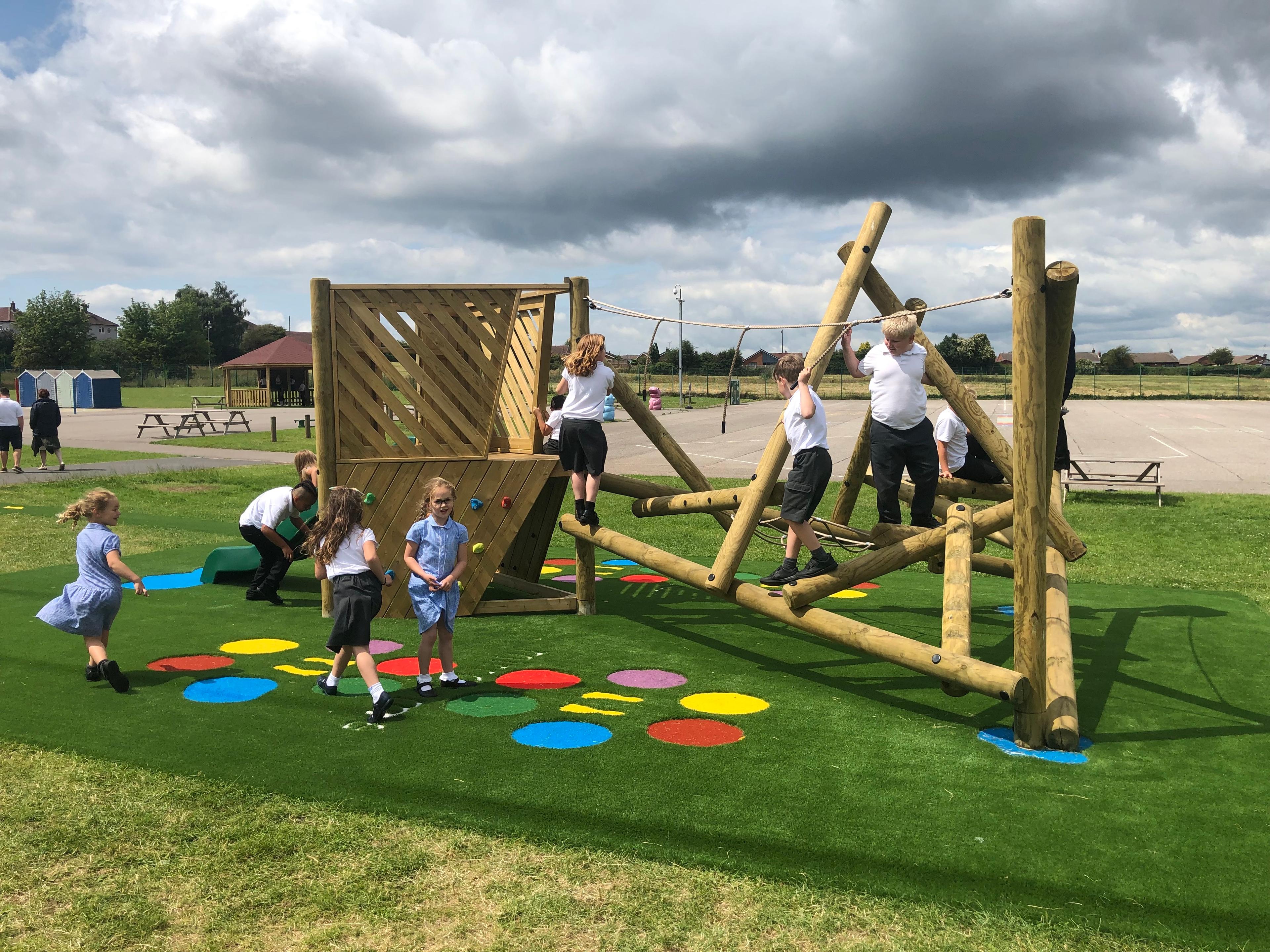 Wooden Bowfell Climbing Frame with Platform and Slide in school playground.