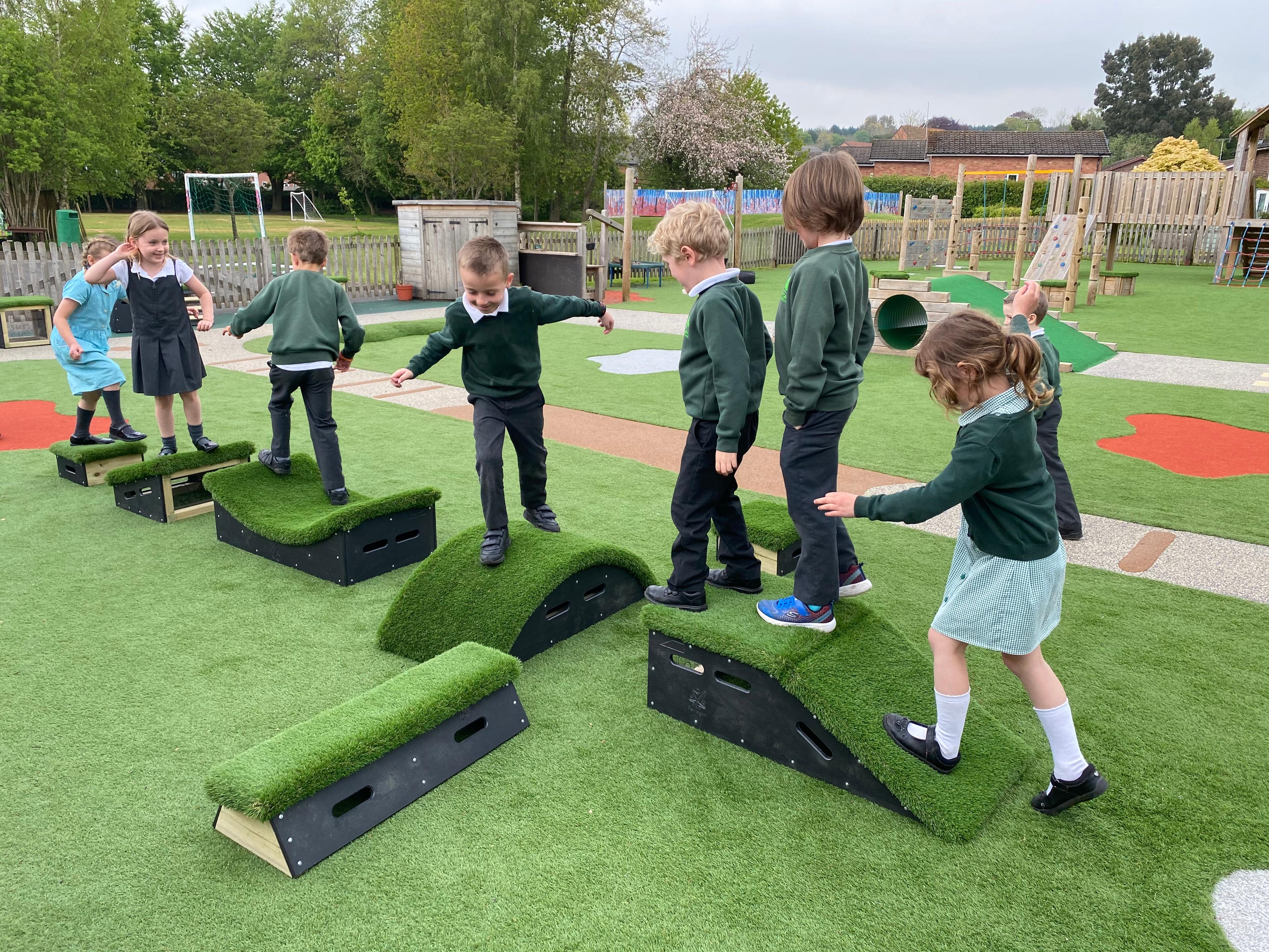 7 children walking in a line on a formation of blocks