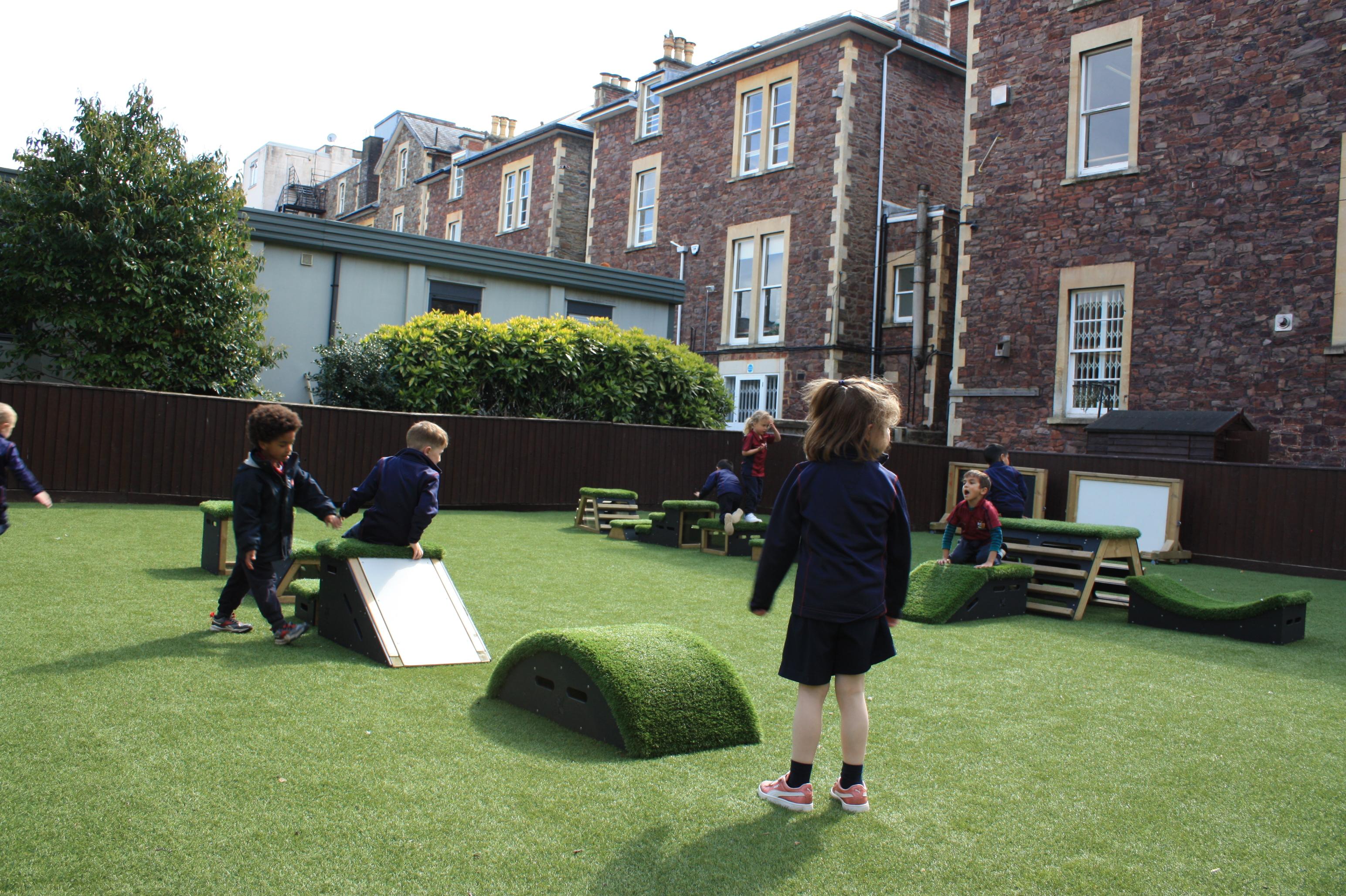 Primary School children playing out outside on grass-topped Get Set, Go! Blocks - Cheviot Set.