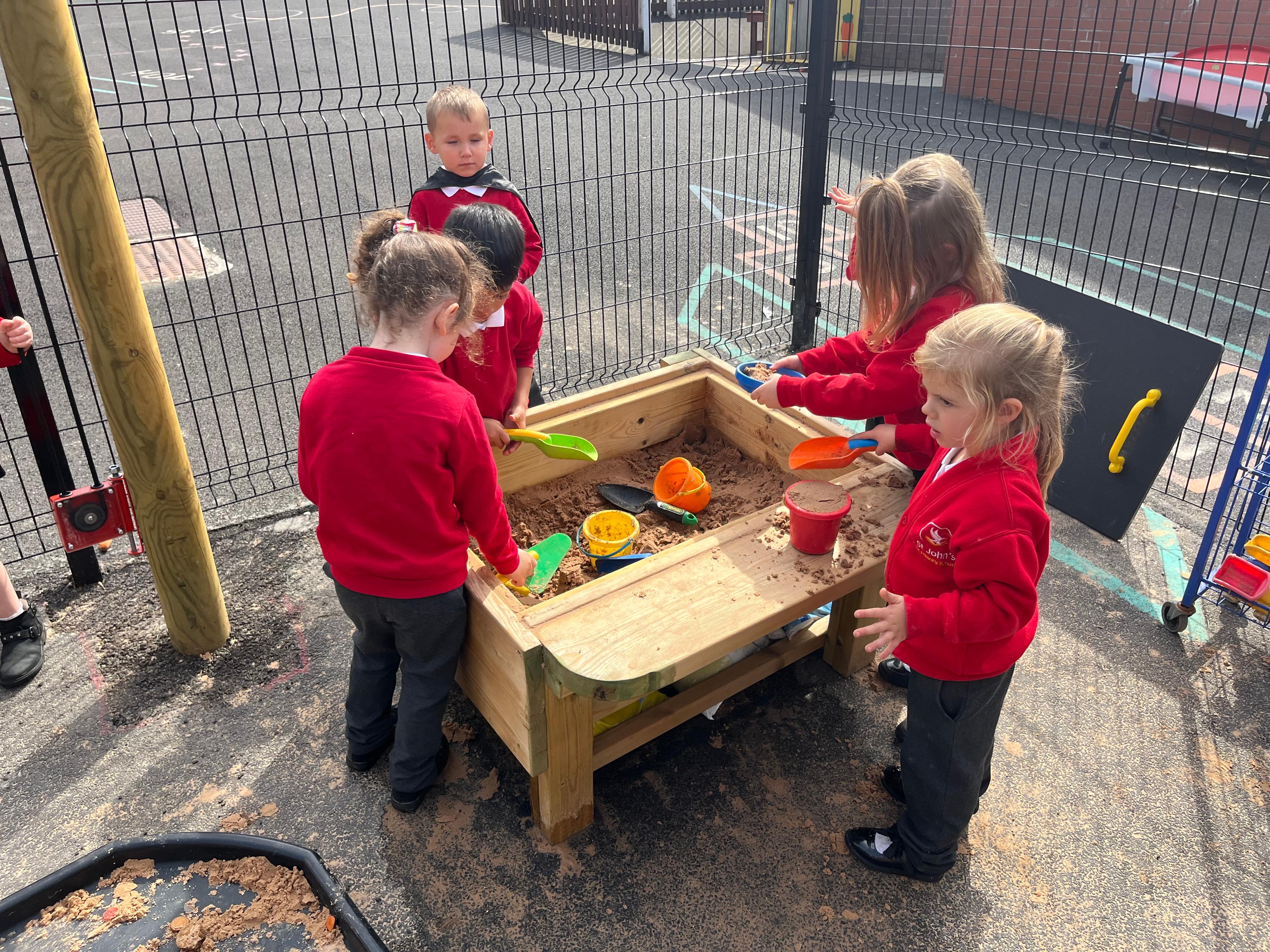 A group of children around a sand table