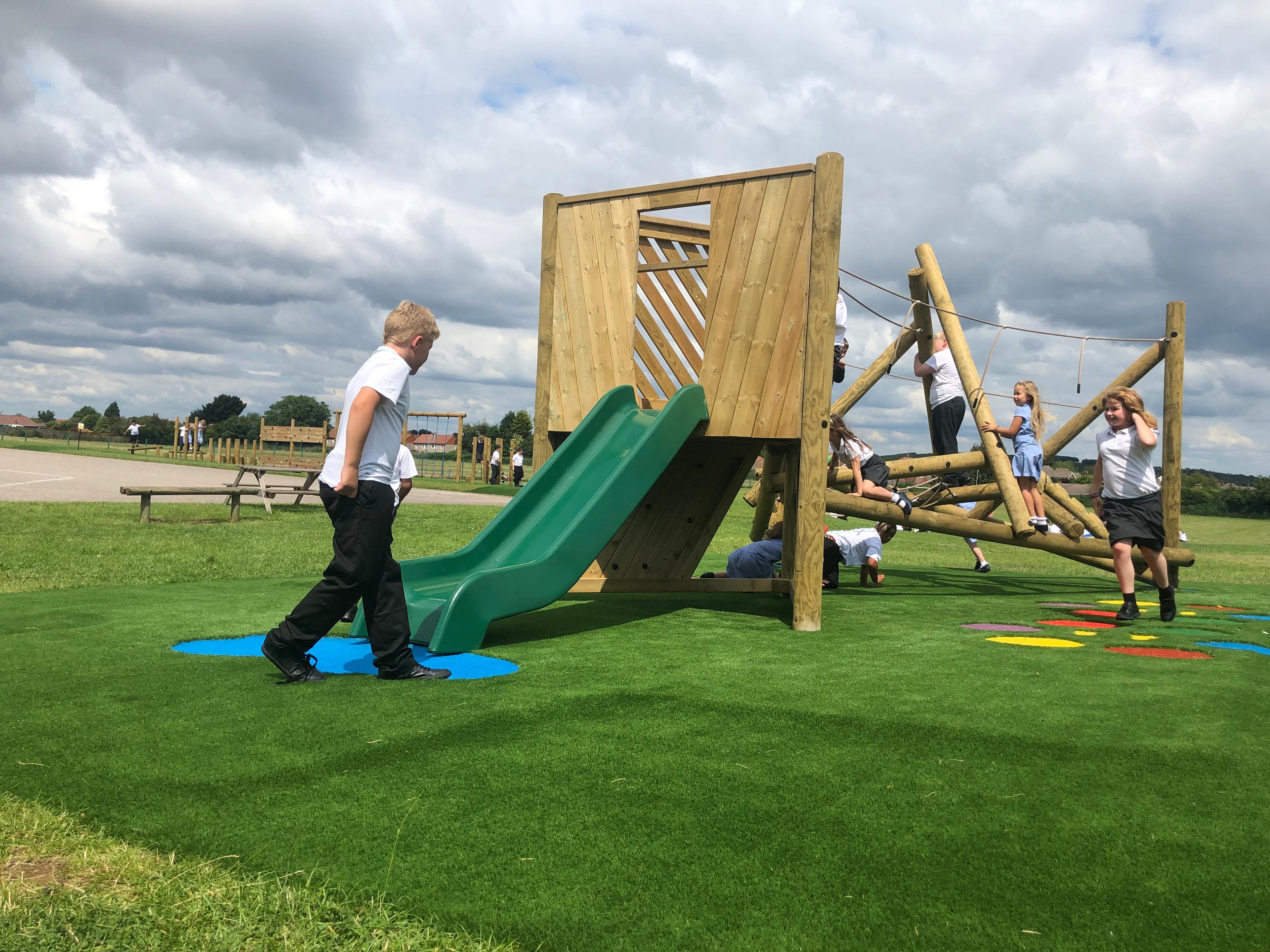 Wooden Bowfell Climbing Frame with Platform and Slide in school playground.