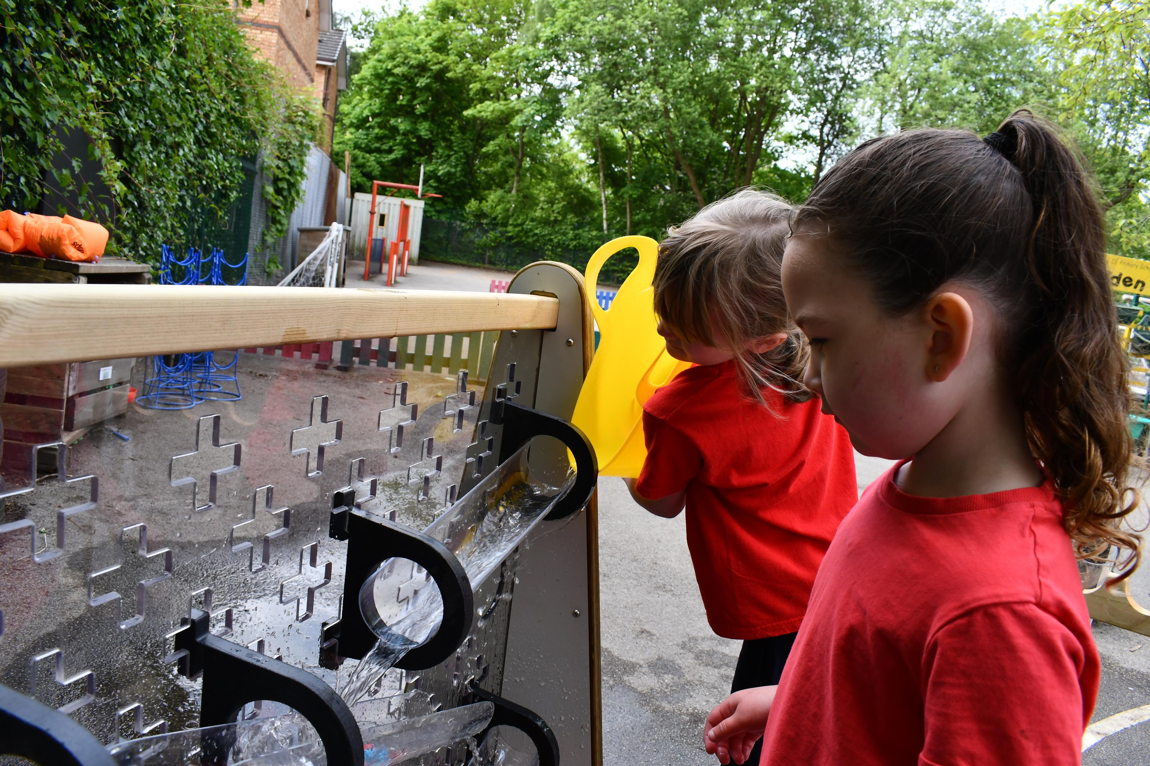 Children playing with the water wall that makes up part of the Pioneer Messy Play Package