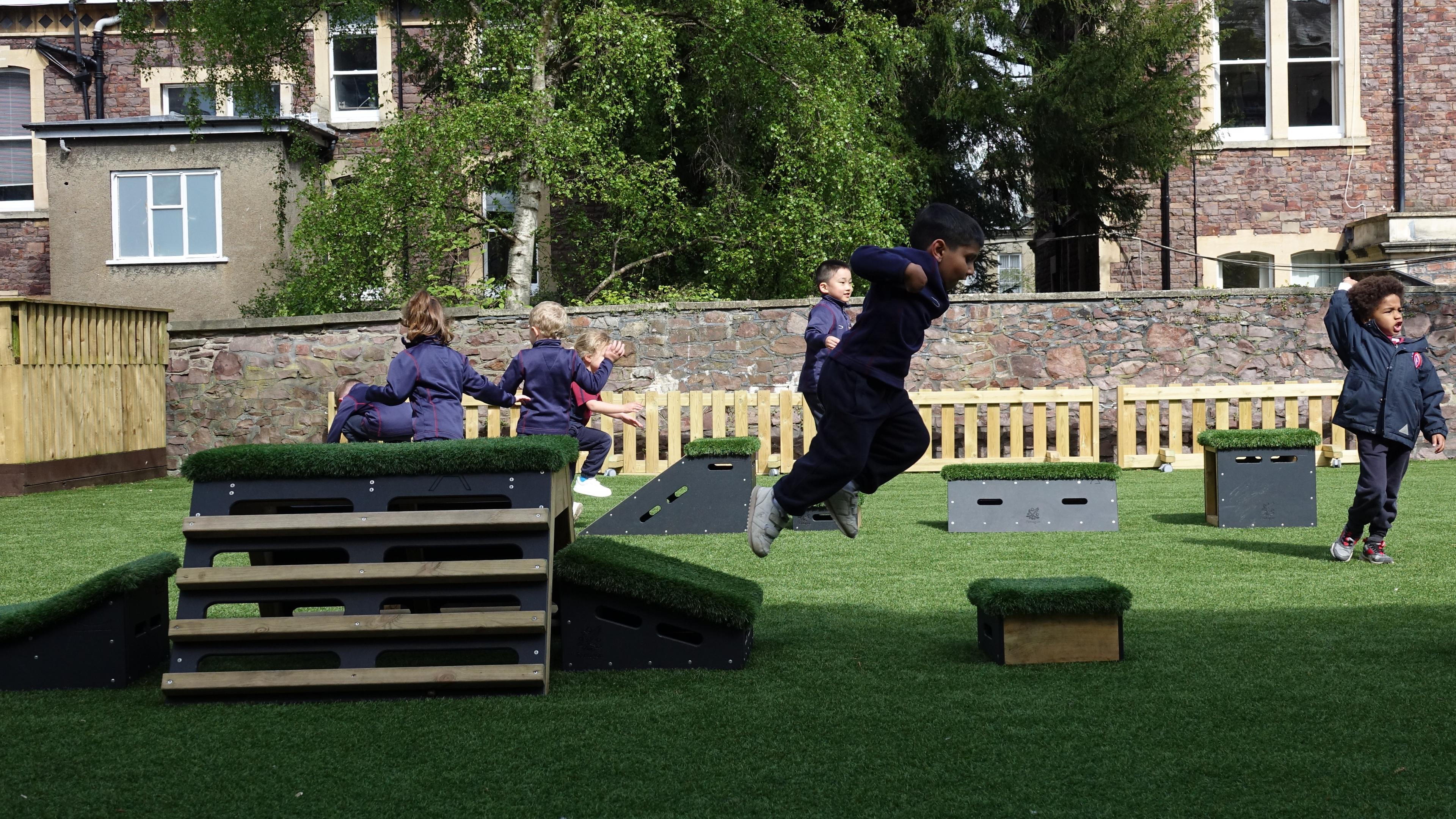 Primary School children playing out outside on grass-topped Get Set, Go! Blocks - Cheviot Set.