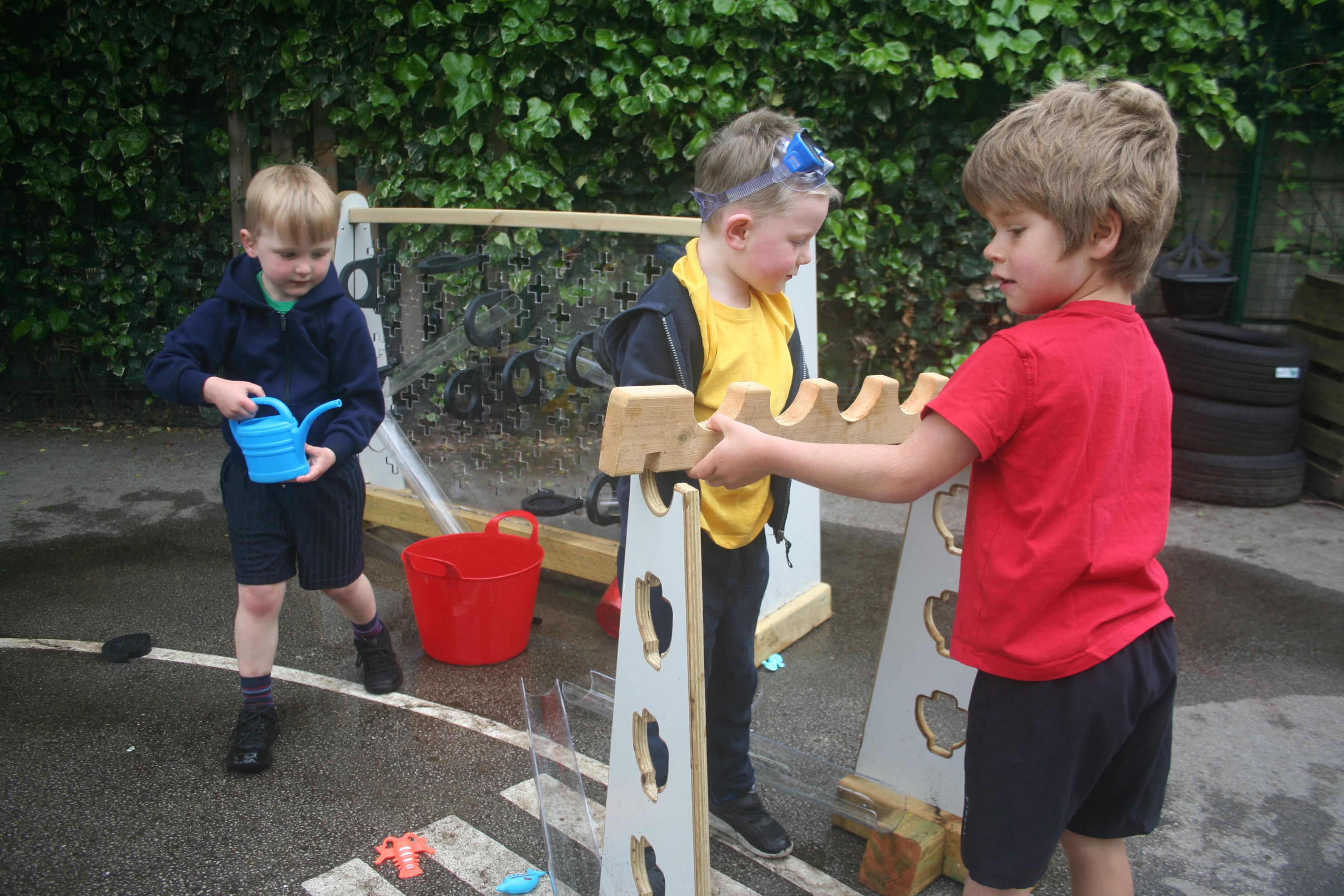 Children playing with water channels and water wall that make up part of the Pioneer Messy Play Package