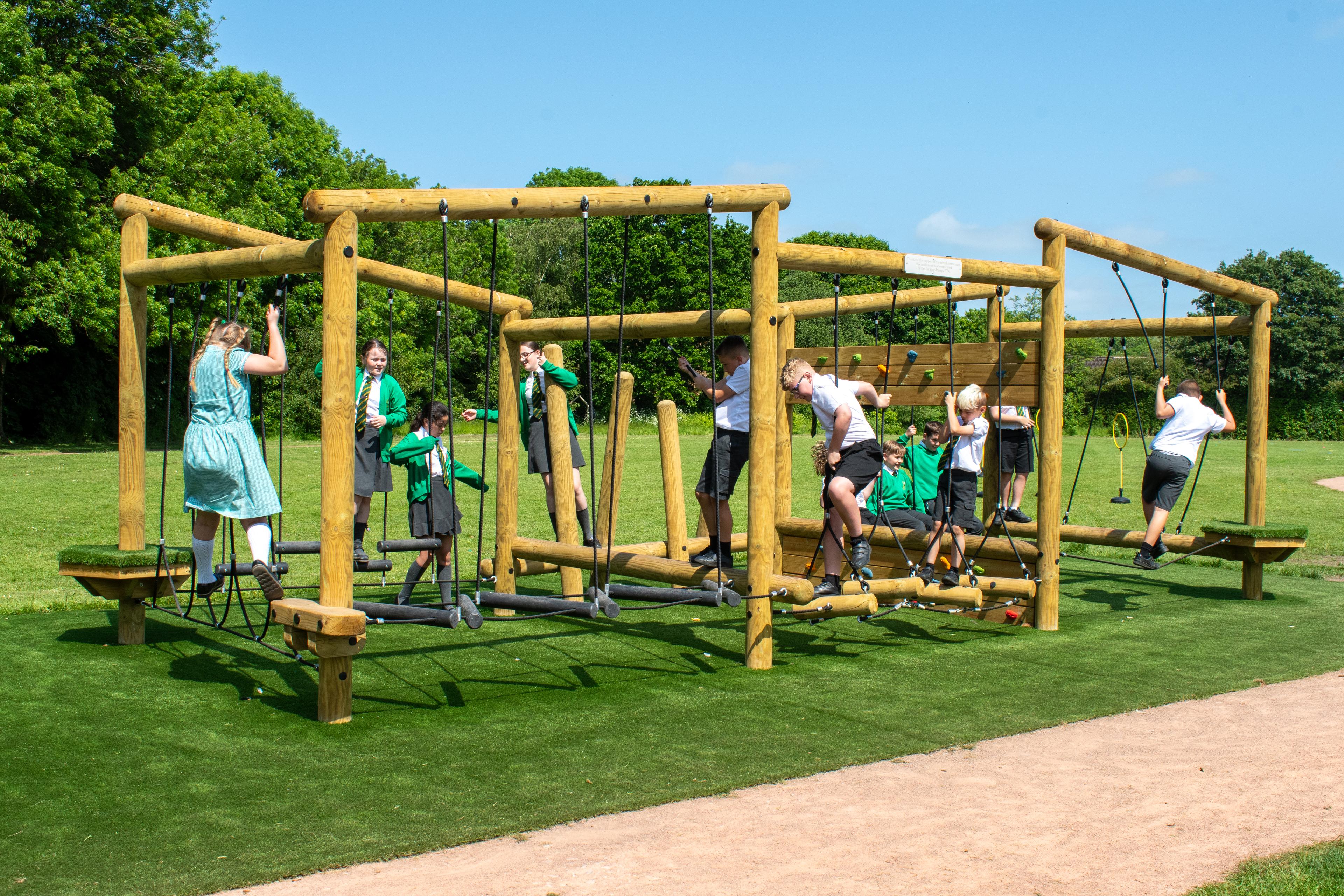 Wooden Kielder Forest Circuit Climbing Frame with multiple children playing on it.